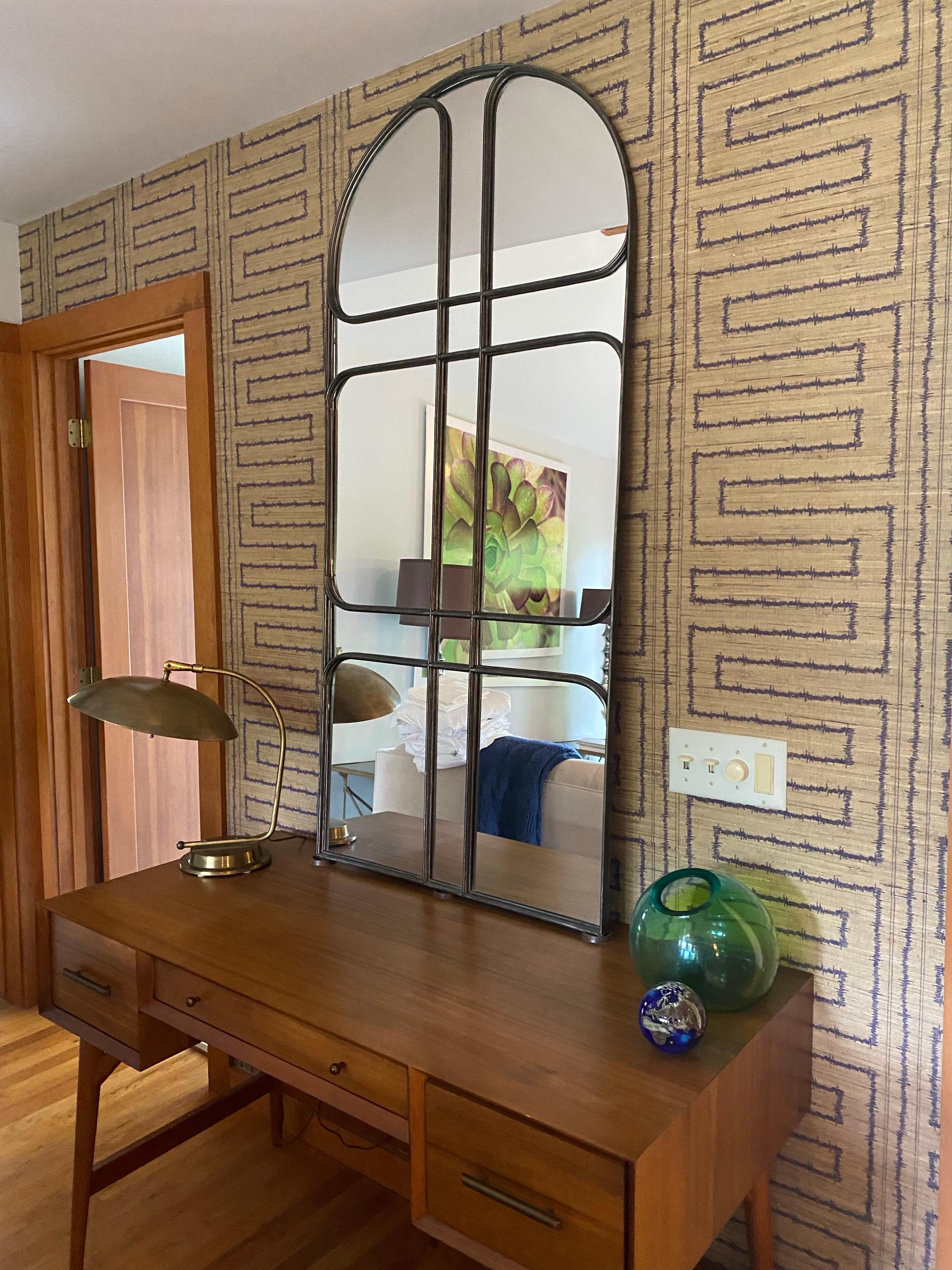 Si tratta di un grande specchio ad arco in stile Art Nouveau. Realizzato in metallo, presenta diversi pannelli a specchio rettangolari e arcuati all'interno di una cornice metallica a griglia.  Il piano ad arco gli conferisce un aspetto industriale