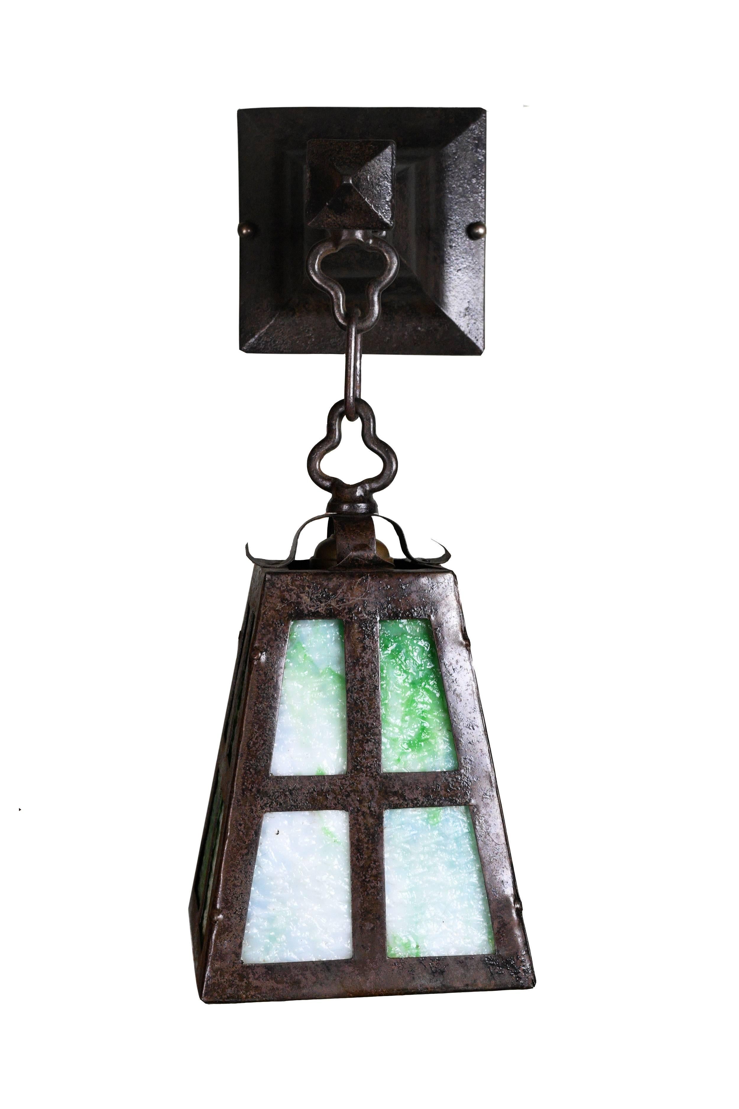 Beautiful Arts & Crafts style iron sconce. The dark, sturdy iron body makes a contrast with the bright green slag glass, and the combination is definitely eye-catching, 

circa 1920.
Finish: Painted
One medium socket.

We find that early antique