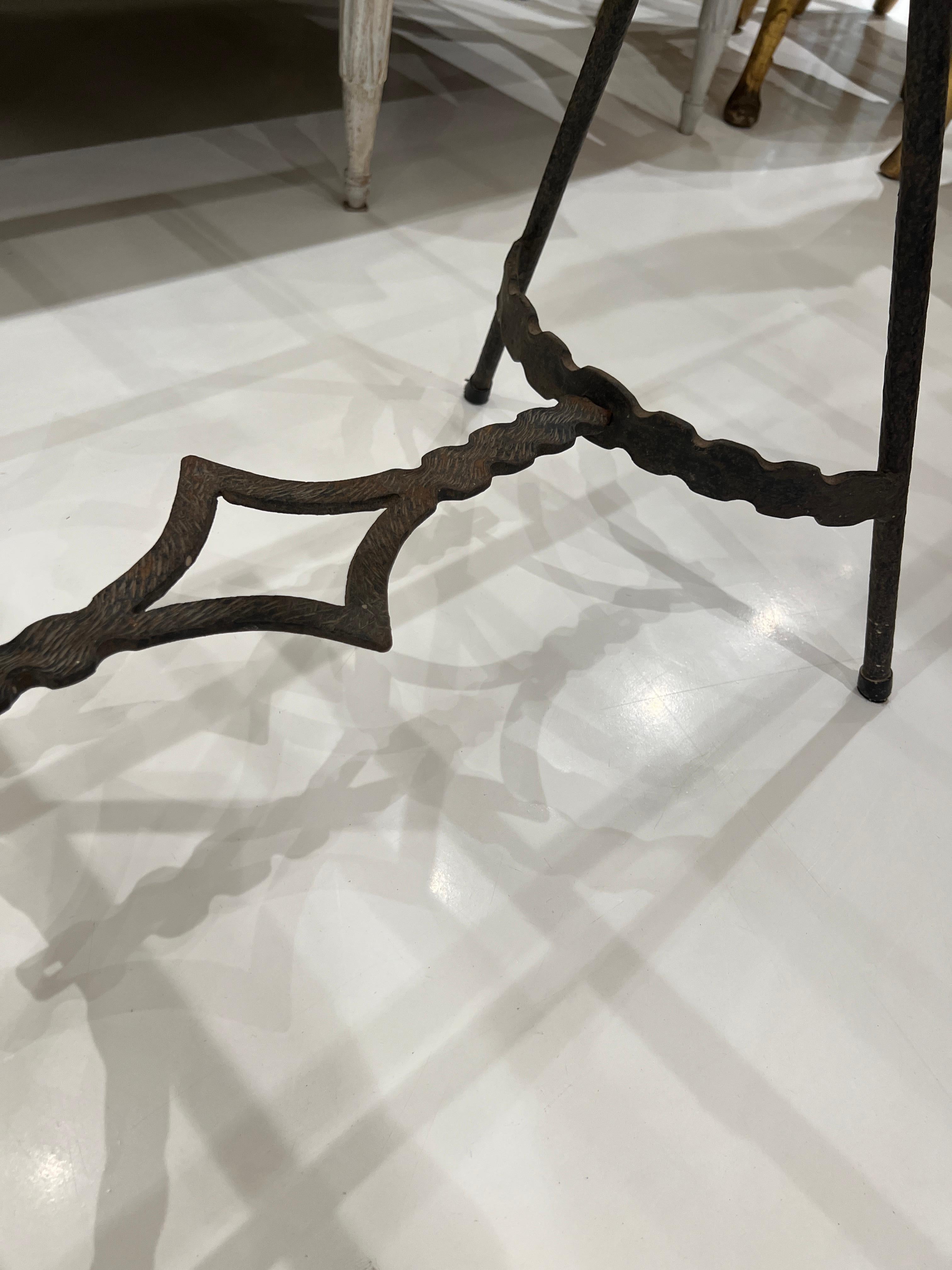 Wrought iron table with interesting details at the base.  New limestone top has been installed.