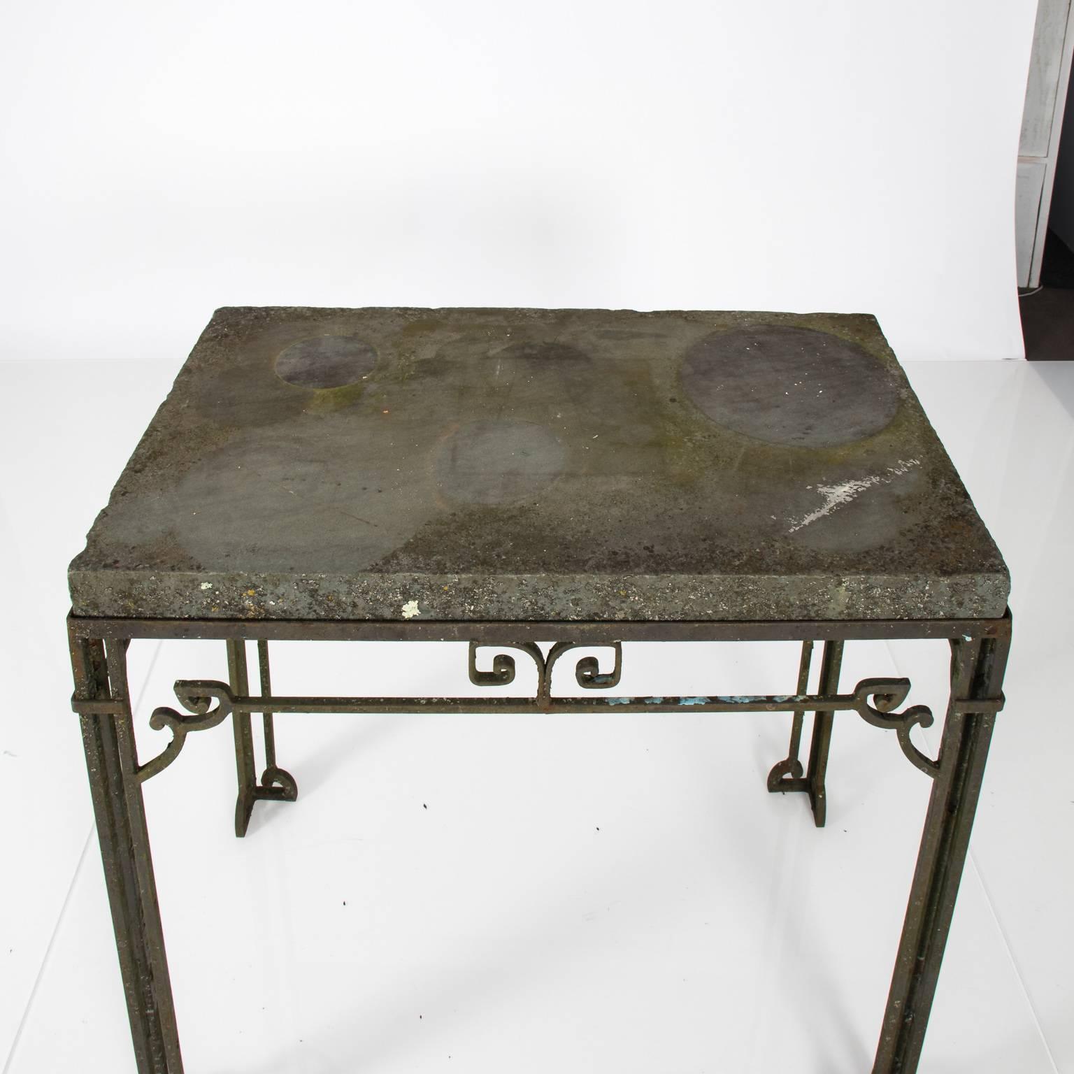 Contemporary iron base garden table with a slate top in a weathered finish.
 