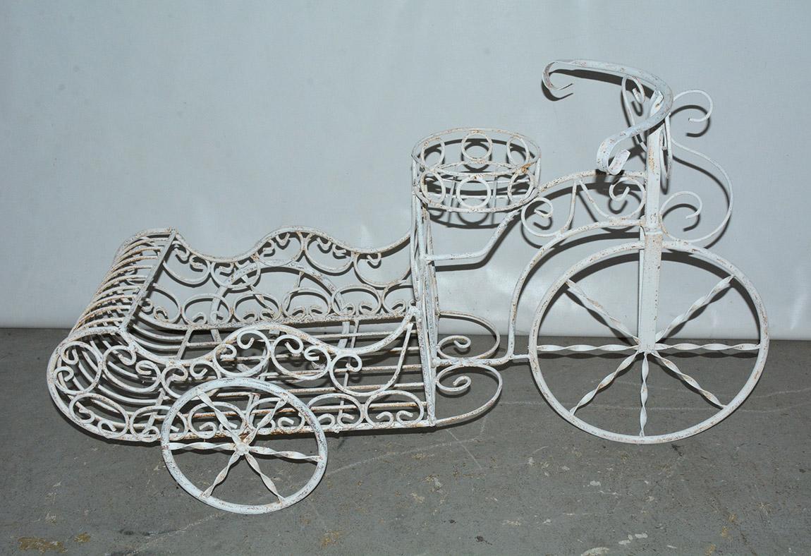 Wonderfully charming painted outdoor metal garden planter or lawn sculpture in the form of a tricycle with a sleigh shape back. Suitable as patio sculpture or iron outdoor ornament.