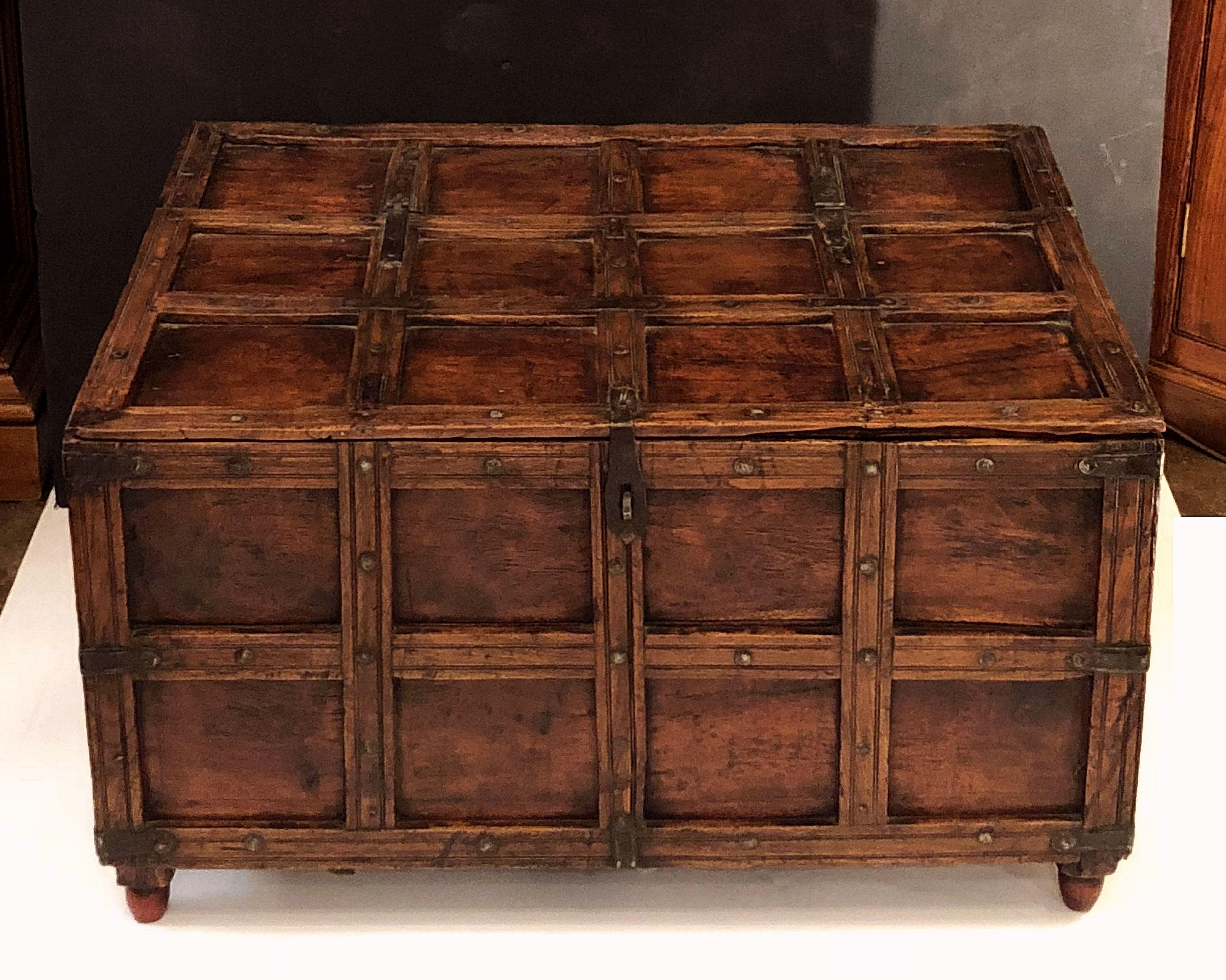 A handsome 19th century rectangular iron-bound wooden stick box trunk or coffer from British Colonial India featuring a hinged top hatch with storage inside. 

Traditionally used for patio storage in Indian havelis or for storing firewood in an