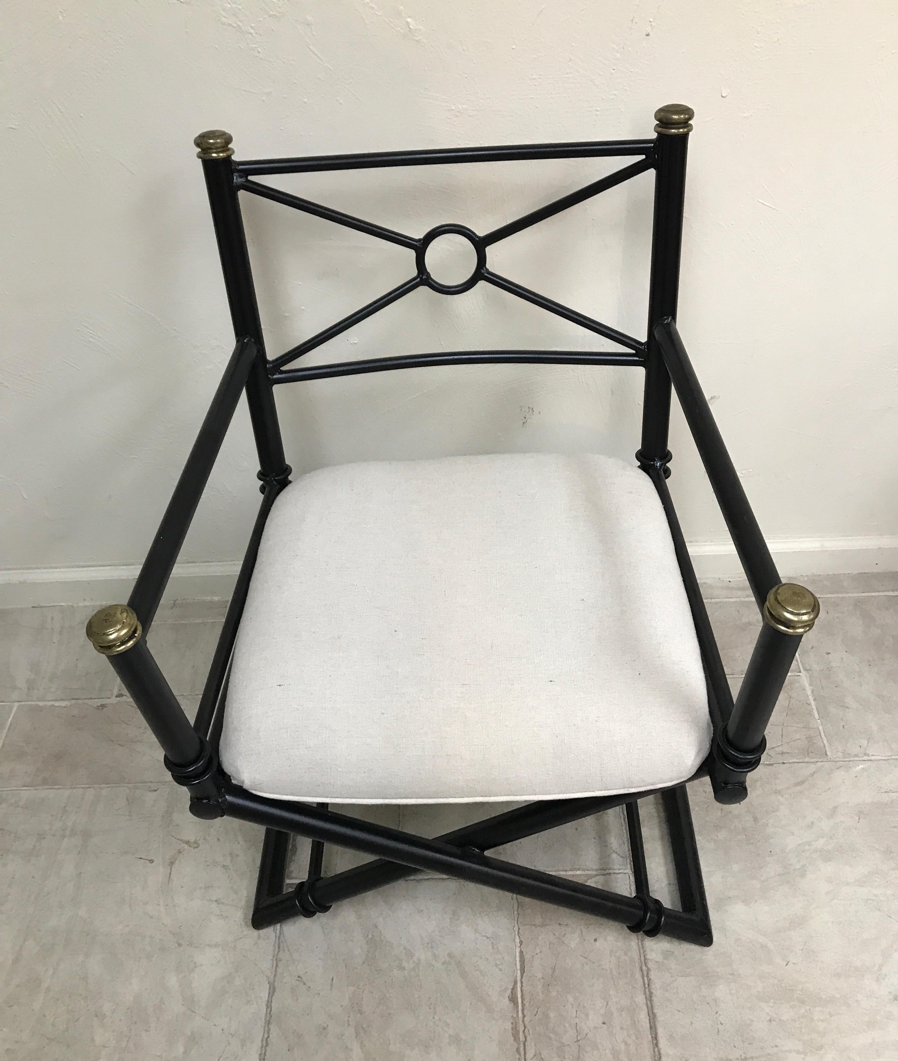 Black painted iron campaign chair with brass accents.