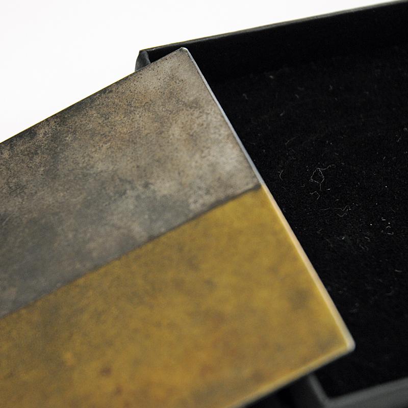 Special Brutalist brooch of iron made by Tore Svensson, Göteborg, Sweden, 1990s.
This rare square shaped brooch has gilded decoration on one half and iron colored surface on the other half. The surface reflexes several different colors depending on