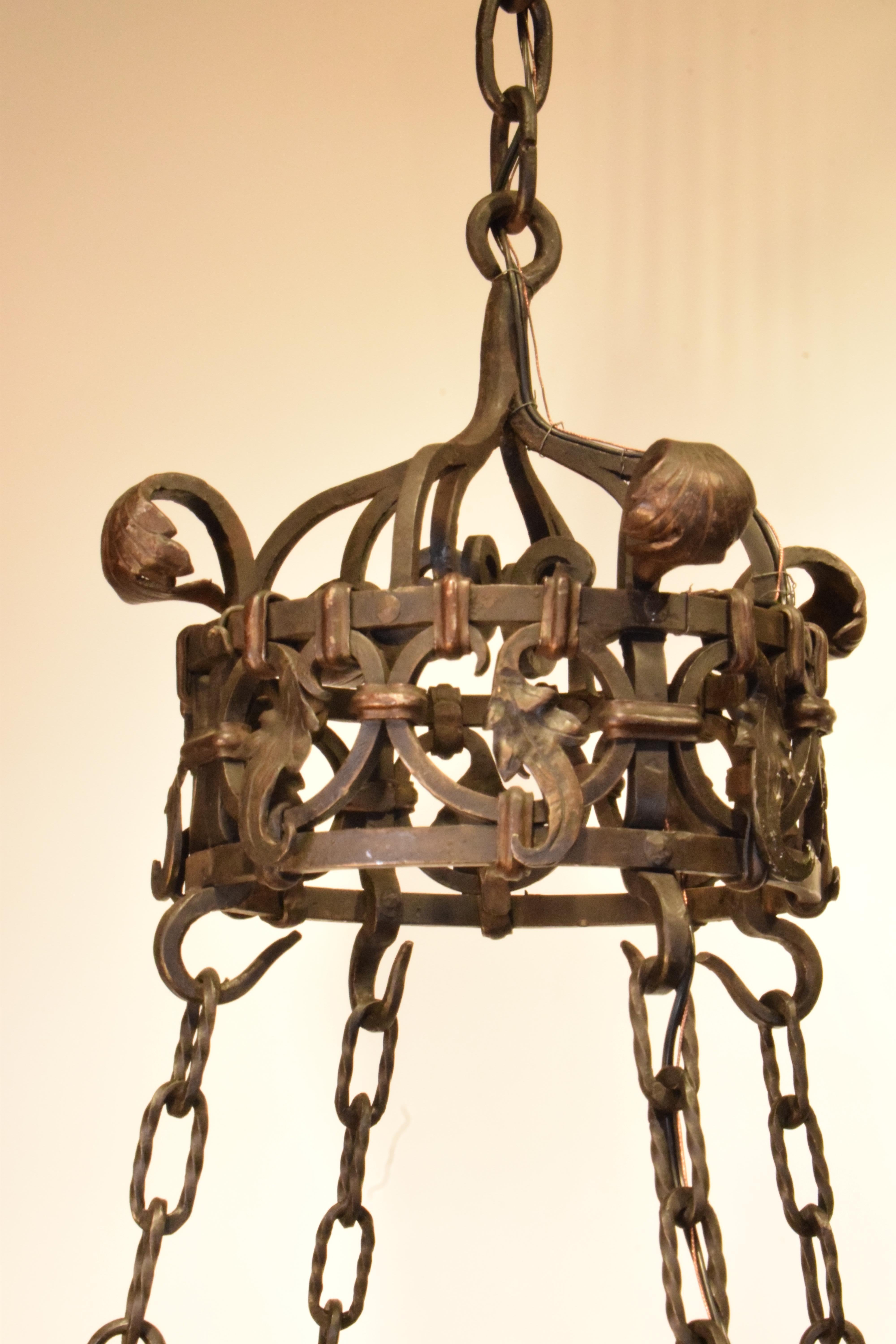 A Very Fine Iron Chandelier, the pierced circle issuing four lights on top and four arms with lights suspended by four chains. Elaborately decorated crown. 
France, circa 1890. 
CW5375