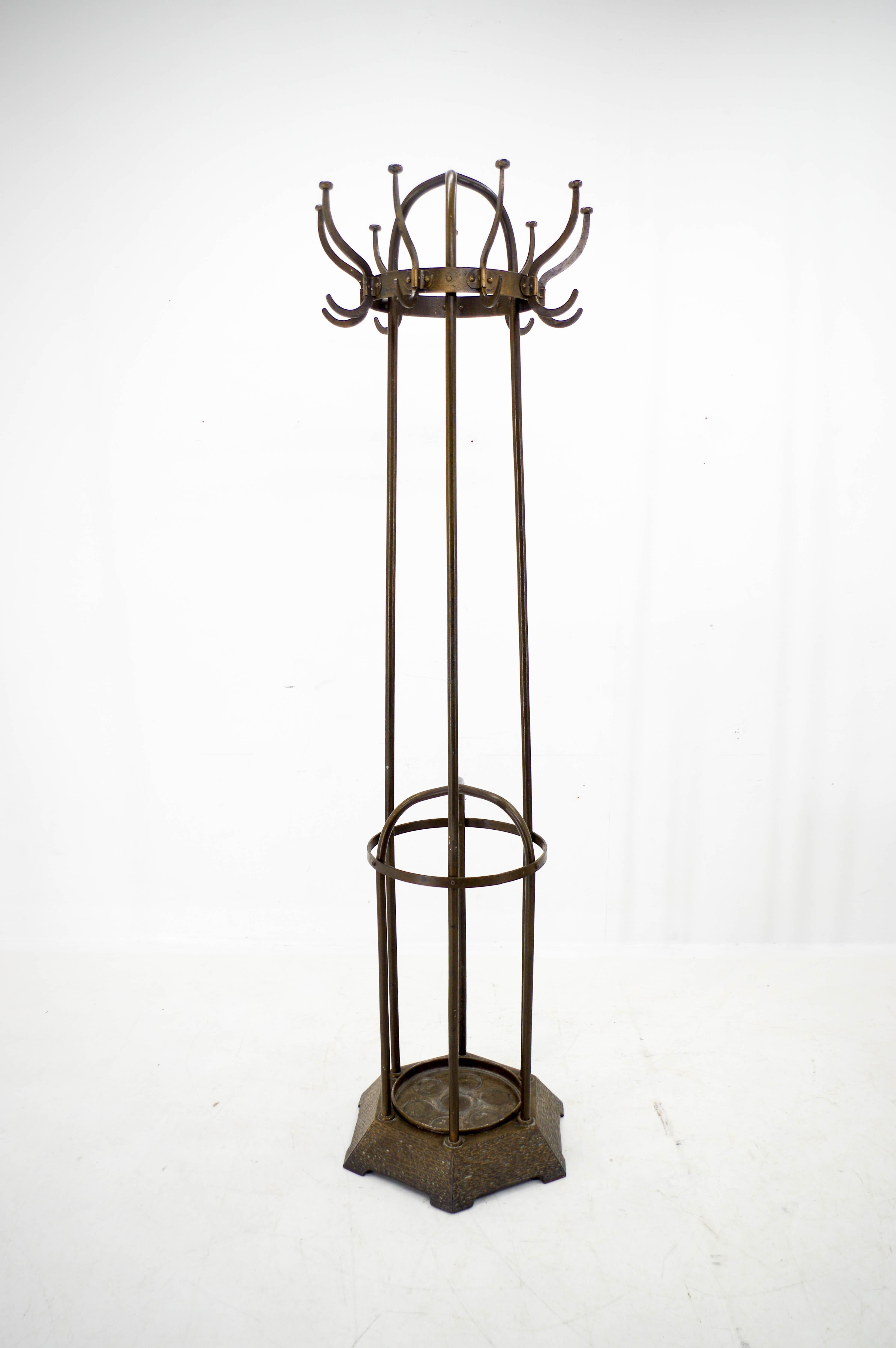 Iron coat rack  with heavy cast iron base and drip tray made by Vichr & Co.
Catalogue model Nr. 345 with antique brass finish.
Very good original condition.
Two items available
