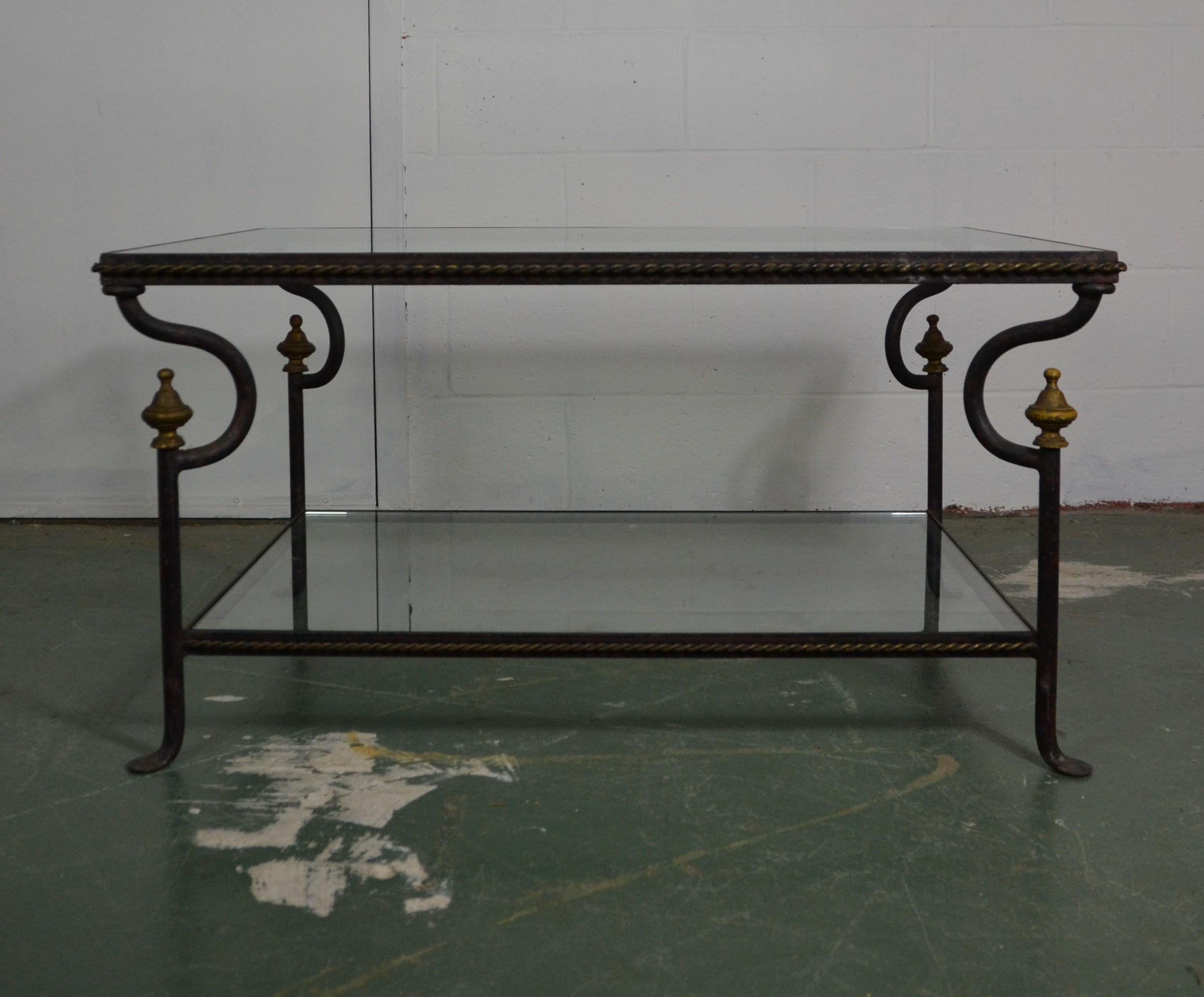 Two-tier glass top iron coffee table with finial accents.