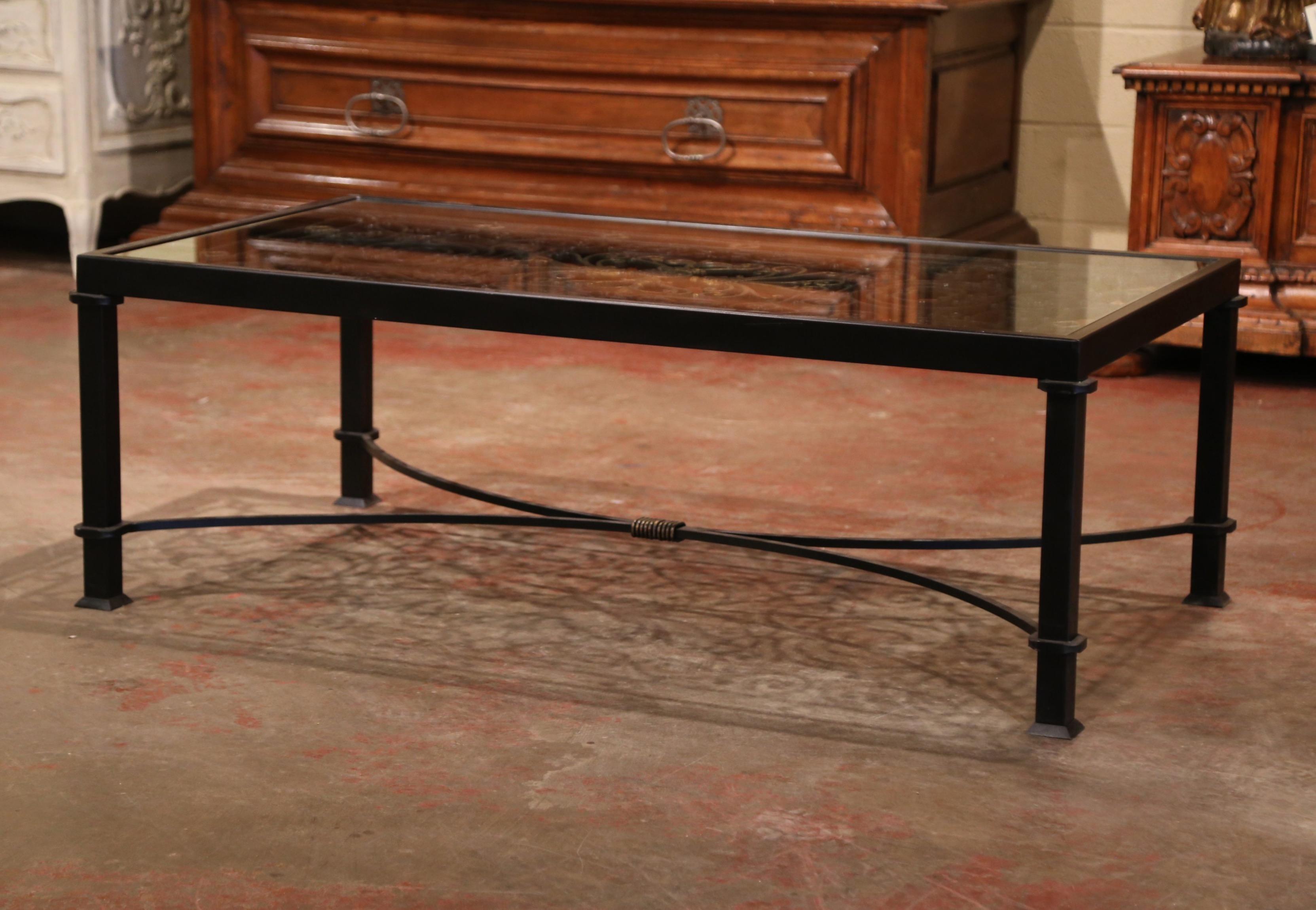 Decorate a den or a formal living room with this iron coffee table; built using an ornate, antique gate from France, circa 1850, the unique table features four square legs decorated with a bottom curved stretcher. The top has intricate scroll motifs
