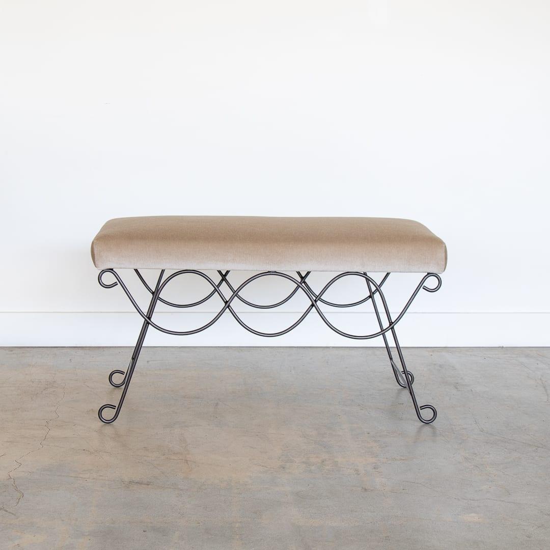 Beautiful iron bench with curved and looped base painted in a matte black finish. Rectangular cushioned seat upholstered in a brown Italian mohair fabric or can be COM. Multiple available, sold individually.