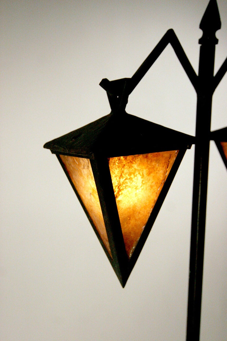 Iron floor table with an arrowhead motif fashioned after the furniture in the Biltmore Hotel built by Albert Chase McArthur and usually attributed to Frank Lloyd Wright. The lamp has two lanterns with mica shades each taking an American standard 60w