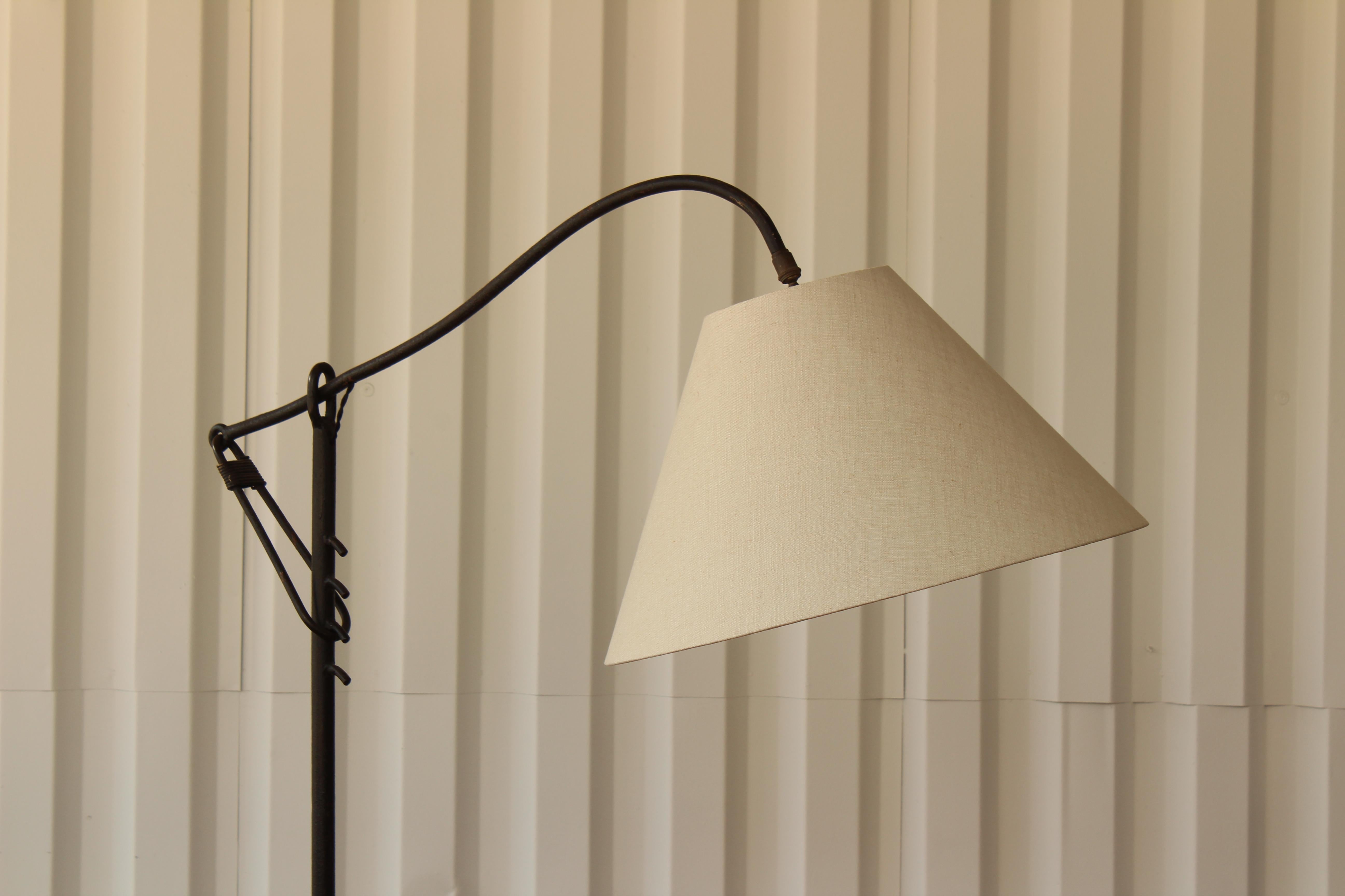 Adjustable iron floor lamp in the style of Jean Royère, France, 1950s. In beautiful condition. Newly rewired and fitted with a custom shade in linen.