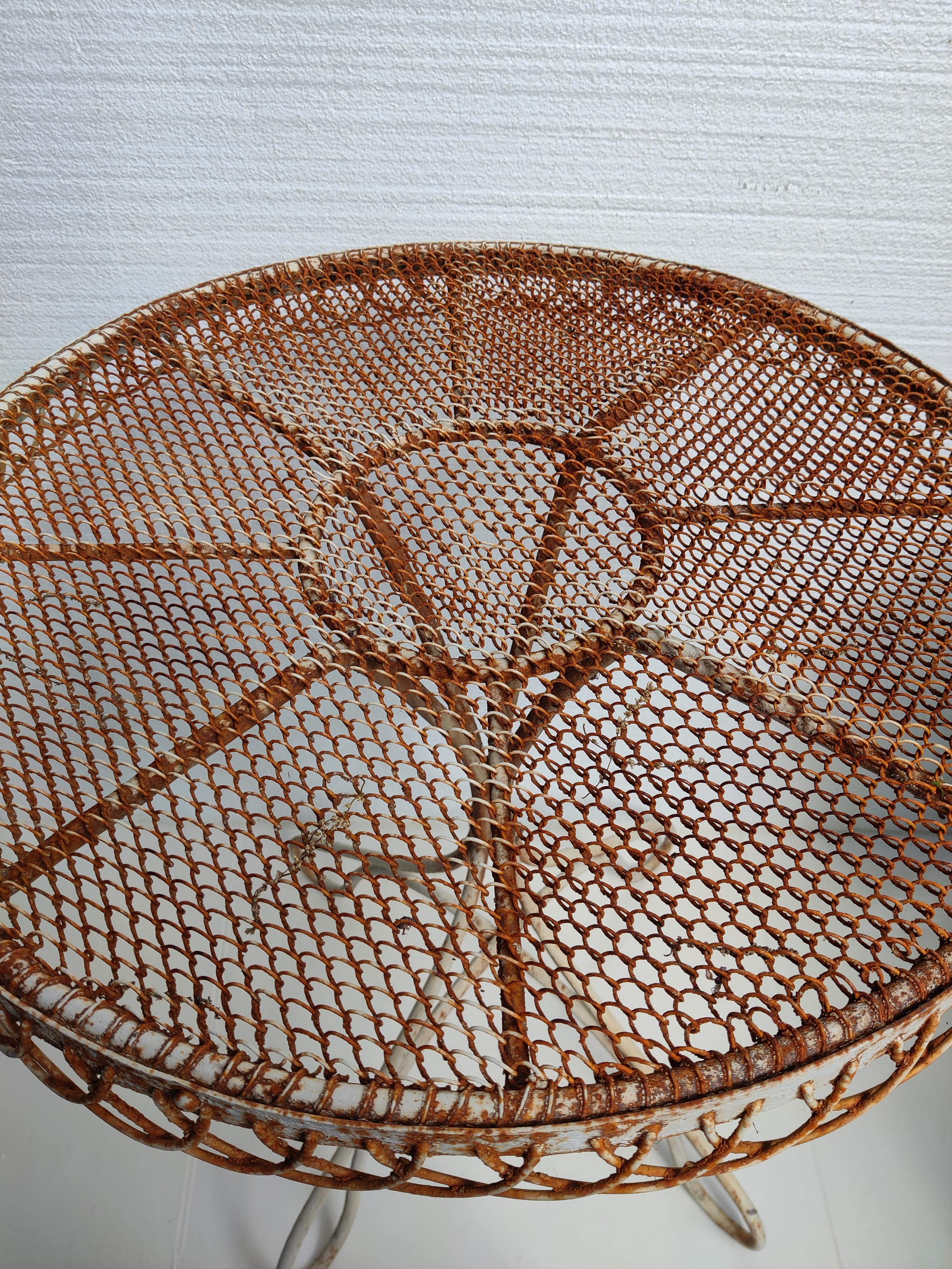 Mid-Century Iron French Bistro Table
Wire mesh top with loop side design.
Top is 23.5 diameter.
Top wire mesh is in good shape but not completely level.   Glass top was added so glasses sit level.   Glass does have scratches from use.   Can be used