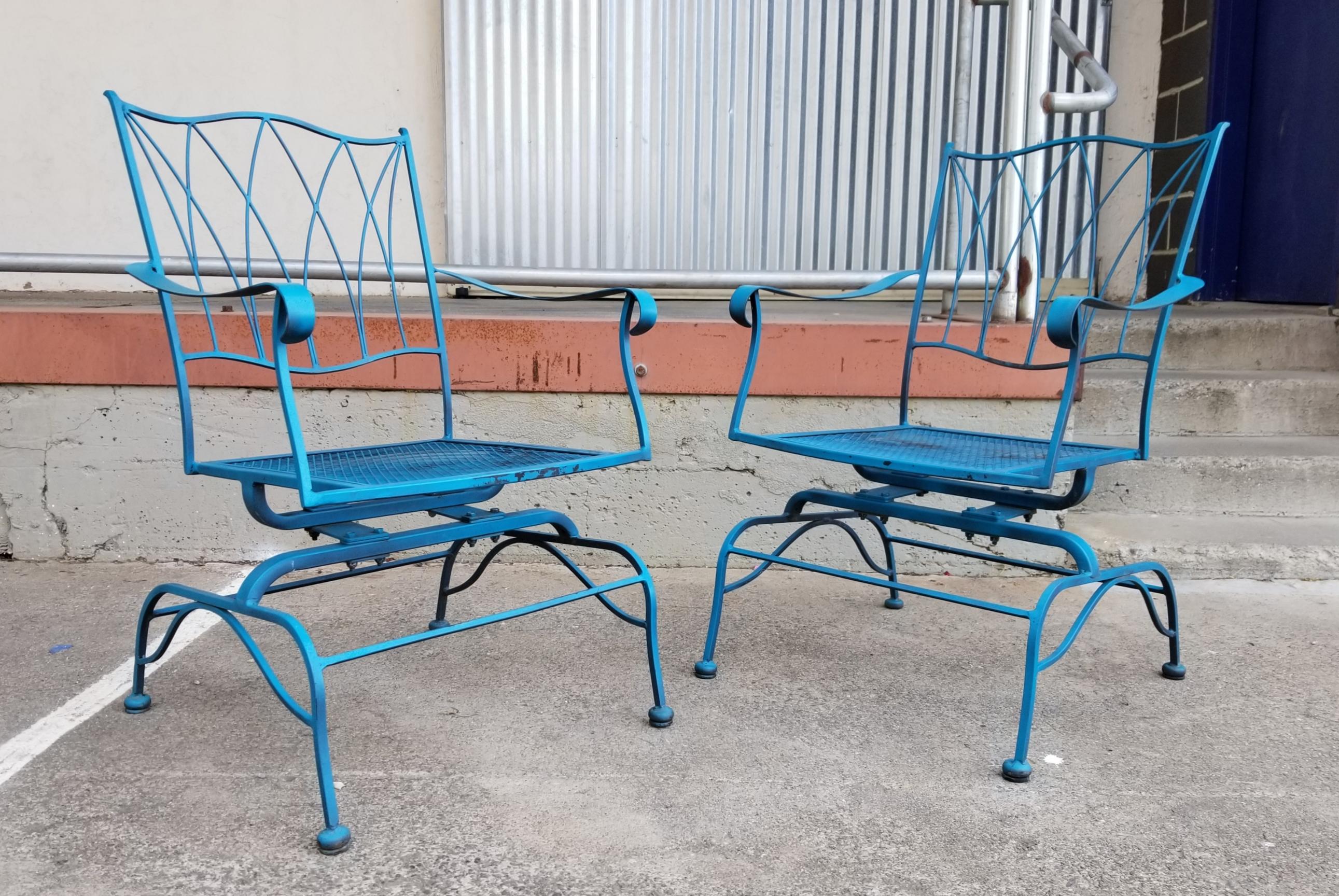 A pair of iron garden chairs with glider / rocker feature.