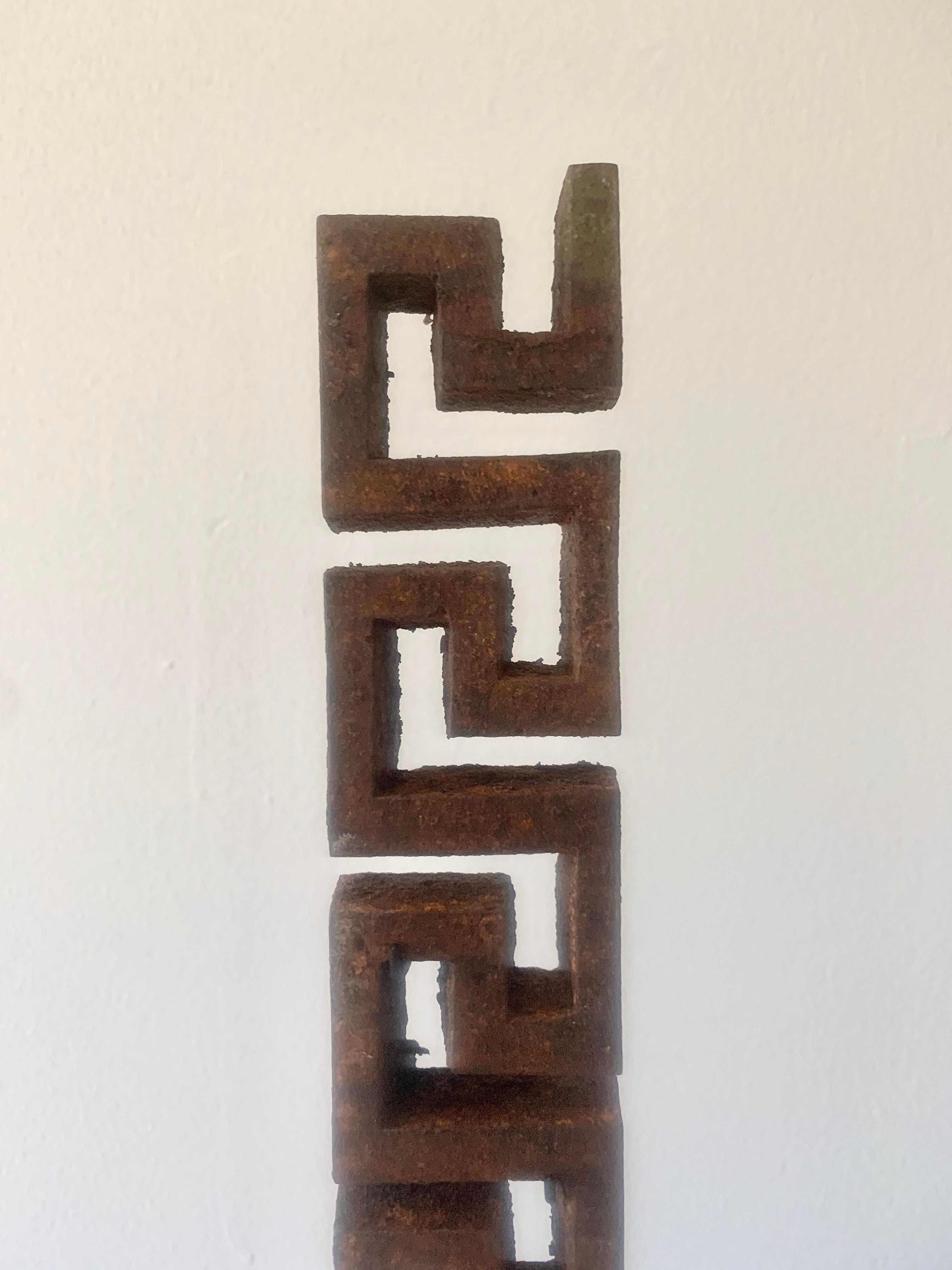 A set of 3 early 20th century iron Greek key architectural fragments on custom black steel mounts. Each fragment measures 2ʺW × 0.5ʺD × 14ʺH while the mounts are 3 different sizes which allow the fragments to be adjusted.
