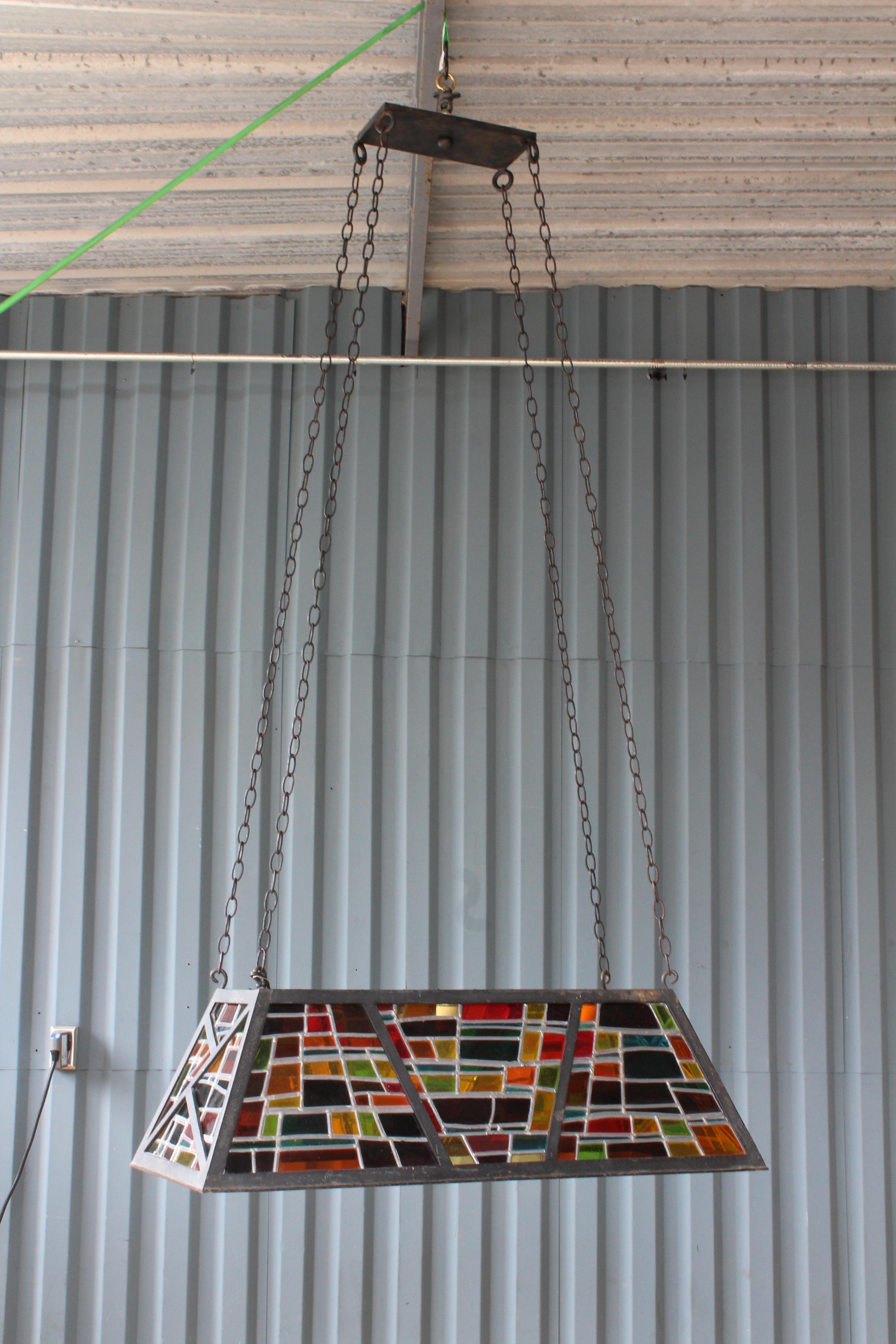 Iron hanging billiard light with multicolored stained glass panels, France, 1960s. Completely refinished with new chain and canopy and new wiring. Uses three standard light bulbs. Chains can be adjusted to your preferred over all height. Overall