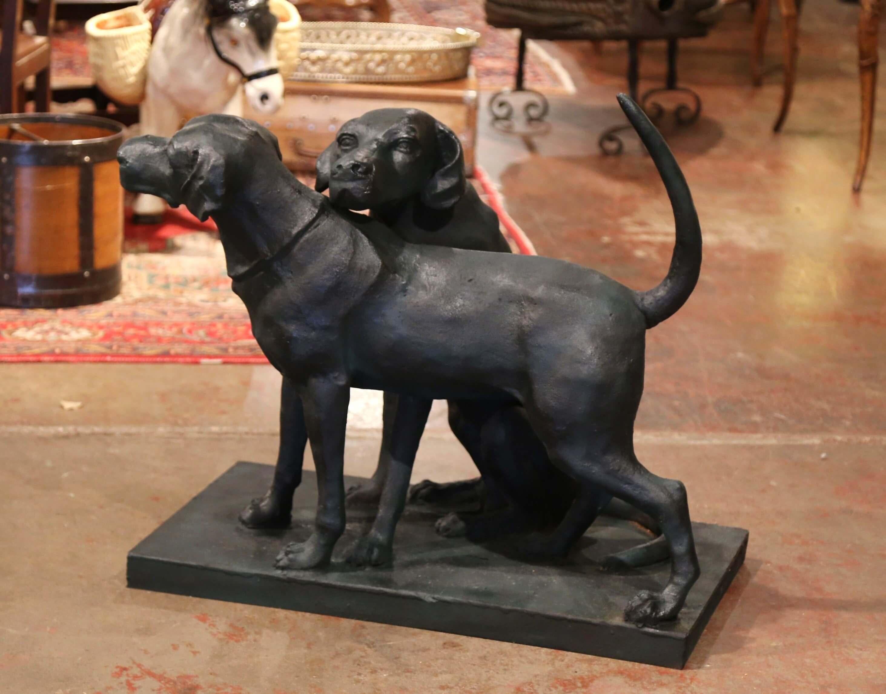Crafted in France, the large sculpture composition features two hunting dogs, one standing, the other sited on his rear end. The life-size canines figure painted dark green, is in excellent condition and would be a wonderful addition to a hunting