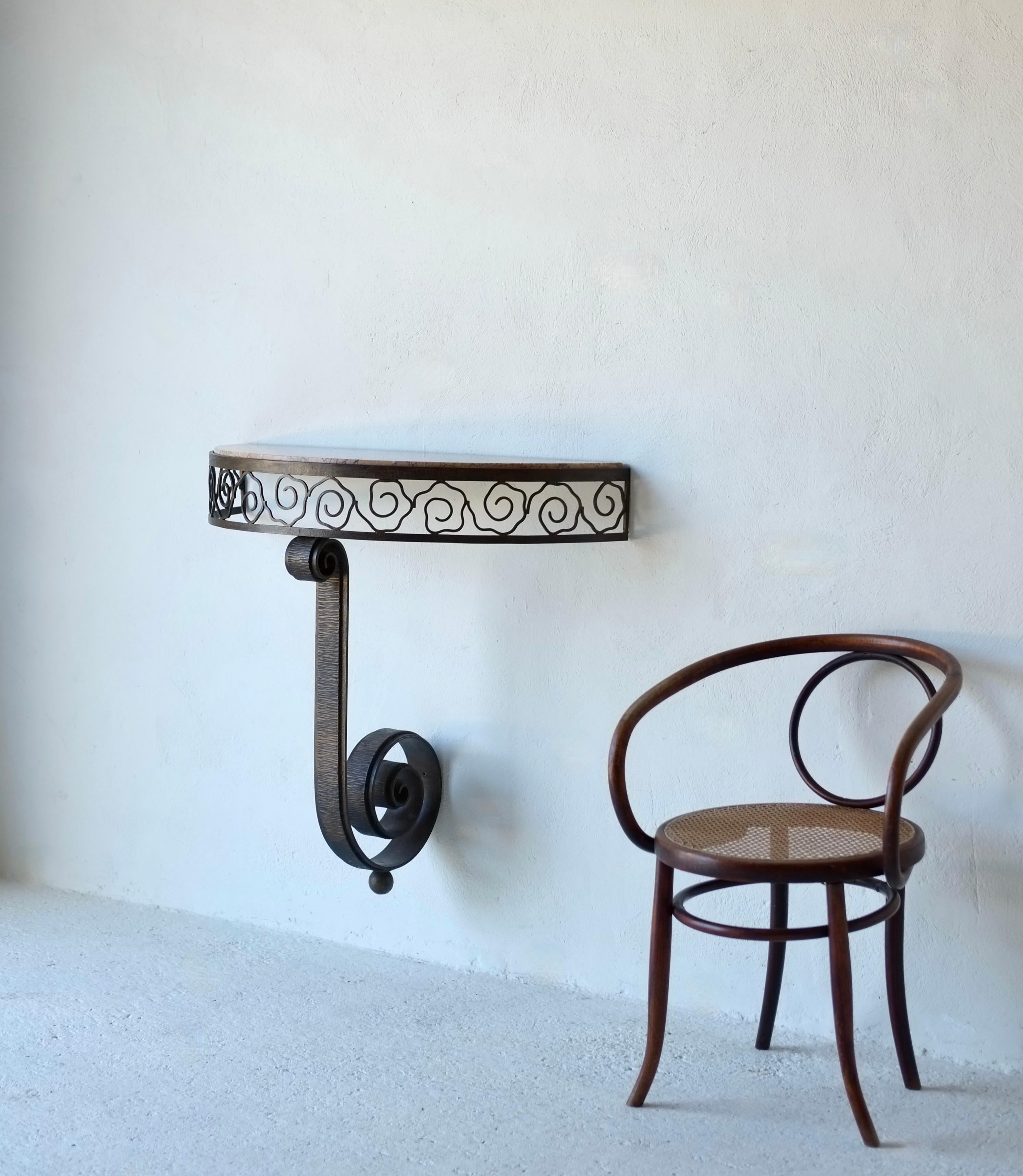 Consola francesa Art Déco de media luna en hierro forjado y mármol atribuida a NICS Frères.

Decorado con un motivo calado estilizado. Base central con volutas que descansa sobre una base de bolas. 

H 88 A 97 P 41 cm

