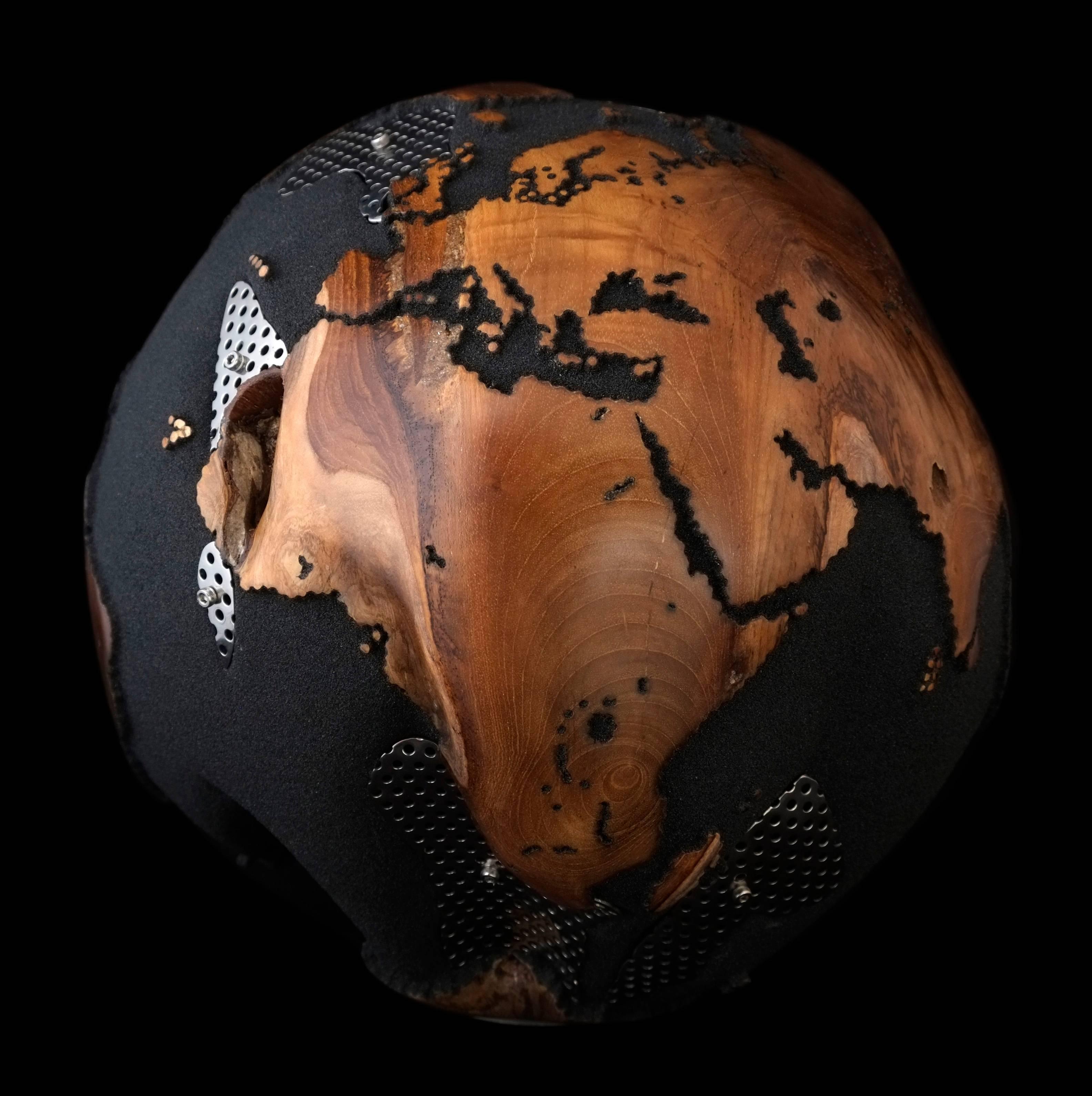Behind the mask of ice that people wear, there beat a heart of fire.

Hand-carved wooden globe made of teak root in volcanic sand finishing, with fascinating features of stainless steel plates that mask the teak root's natural holes fastened by