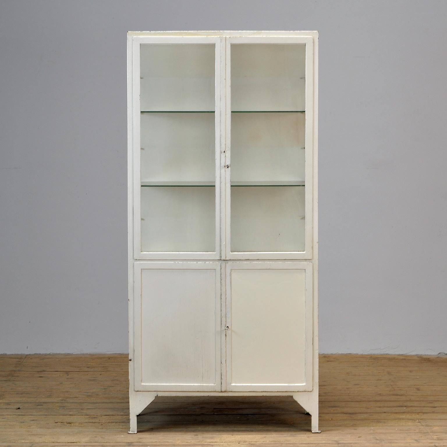 This former medical cabinet was produced in the 1930s in Hungary. It is made of thick iron and glass. In the upper part, there are two new glass shelves. The locks are in perfect working condition.
  