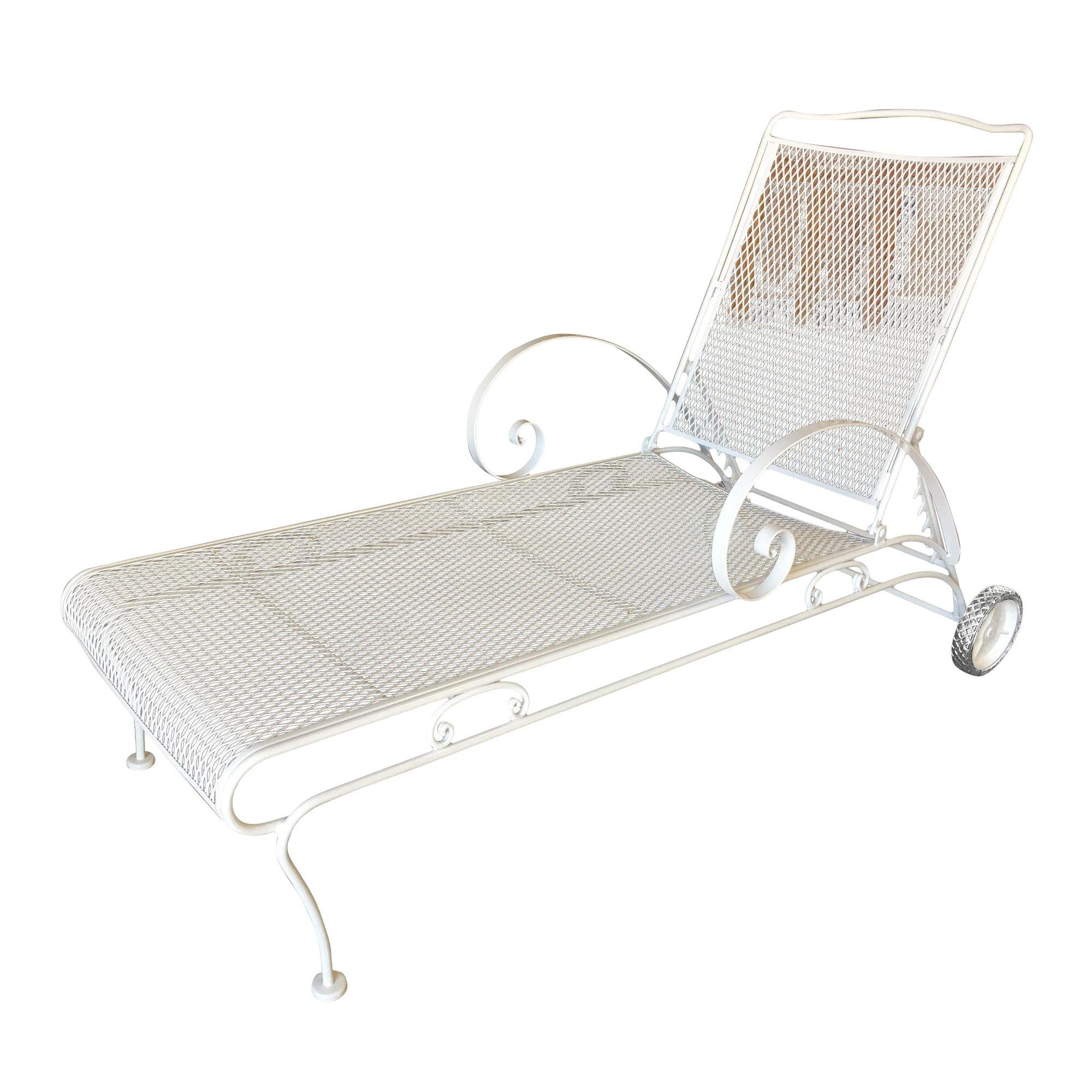 White painted iron outdoor / patio chaise lounge, produced in 1950 by the Woodard Furniture Company. This comfortable and stylish vintage chaise lounge features a fully adjustable reclining back and back wheels for easy moving with large scrolling