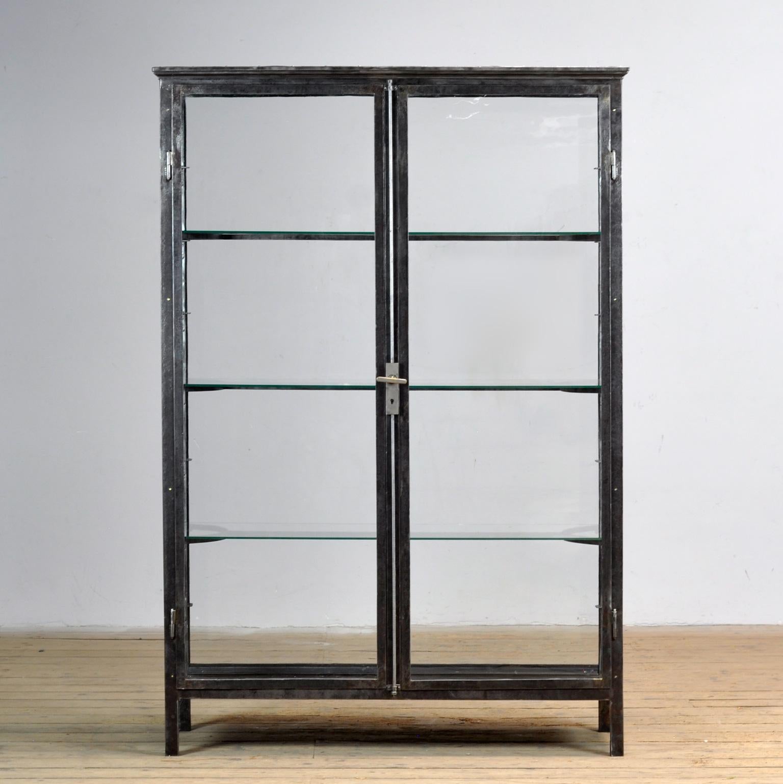 Museumsvitrine aus Eisen, um 1920. Der Schrank ist an vier Seiten verglast. Das Glas auf der Vorderseite und an den Seiten hat noch das ursprüngliche antike Glas. Der Rahmen oben setzt sich auch auf der Rückseite fort. Dadurch eignet sich der