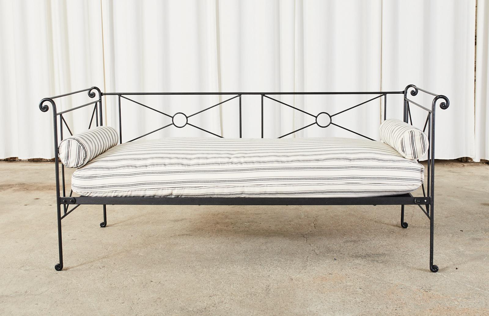 Stylish iron daybed made by Charles P. Rogers crafted in the campaign style with X form neoclassical motifs. The iron frame has scrolled decorative ends on top and bottom. The seat measures 15 inches high without the cushion. Newly upholstered pad