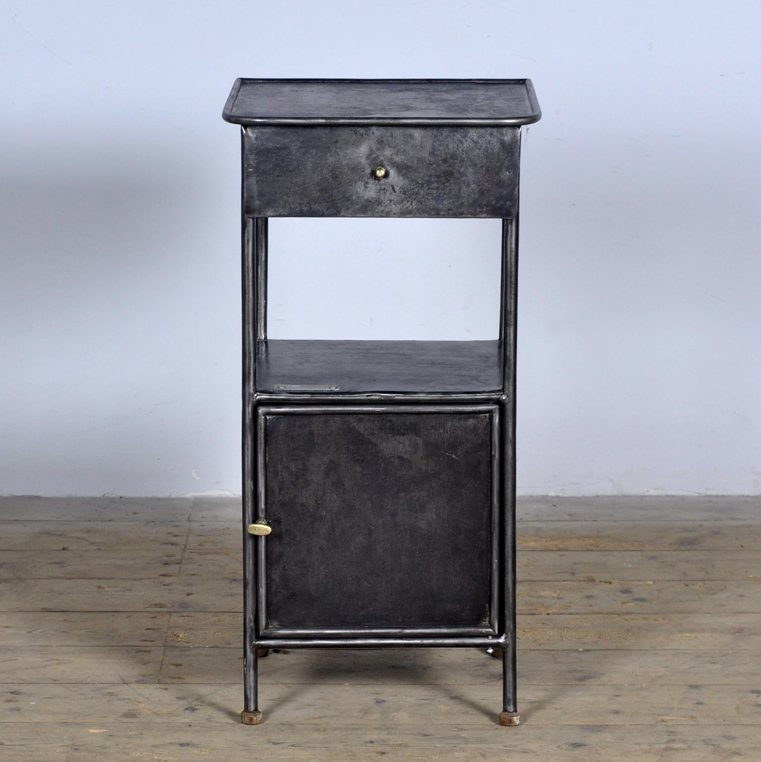 Bedside table made of iron from a hospital in Budapest. With nice details such as the brass knobs and wooden feet. Stripped to the metal and polished. Circa 1910.