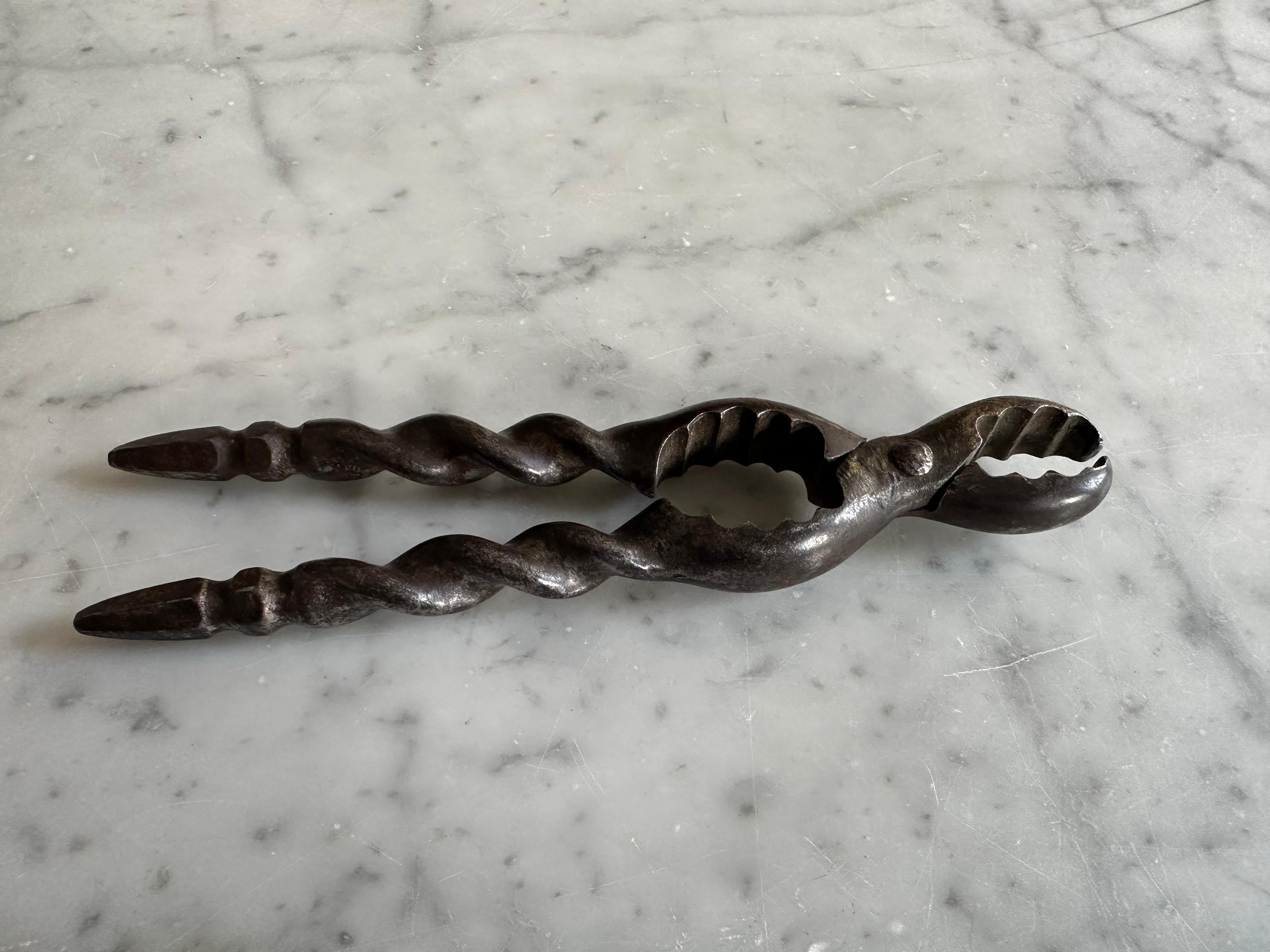 Questo splendido schiaccianoci in ferro invecchiato risale al 1800 circa e molto probabilmente proviene dalla Germania. È un meraviglioso esempio di artigianato utilitaristico con un tocco di eleganza. Il pezzo presenta manici finemente torniti e