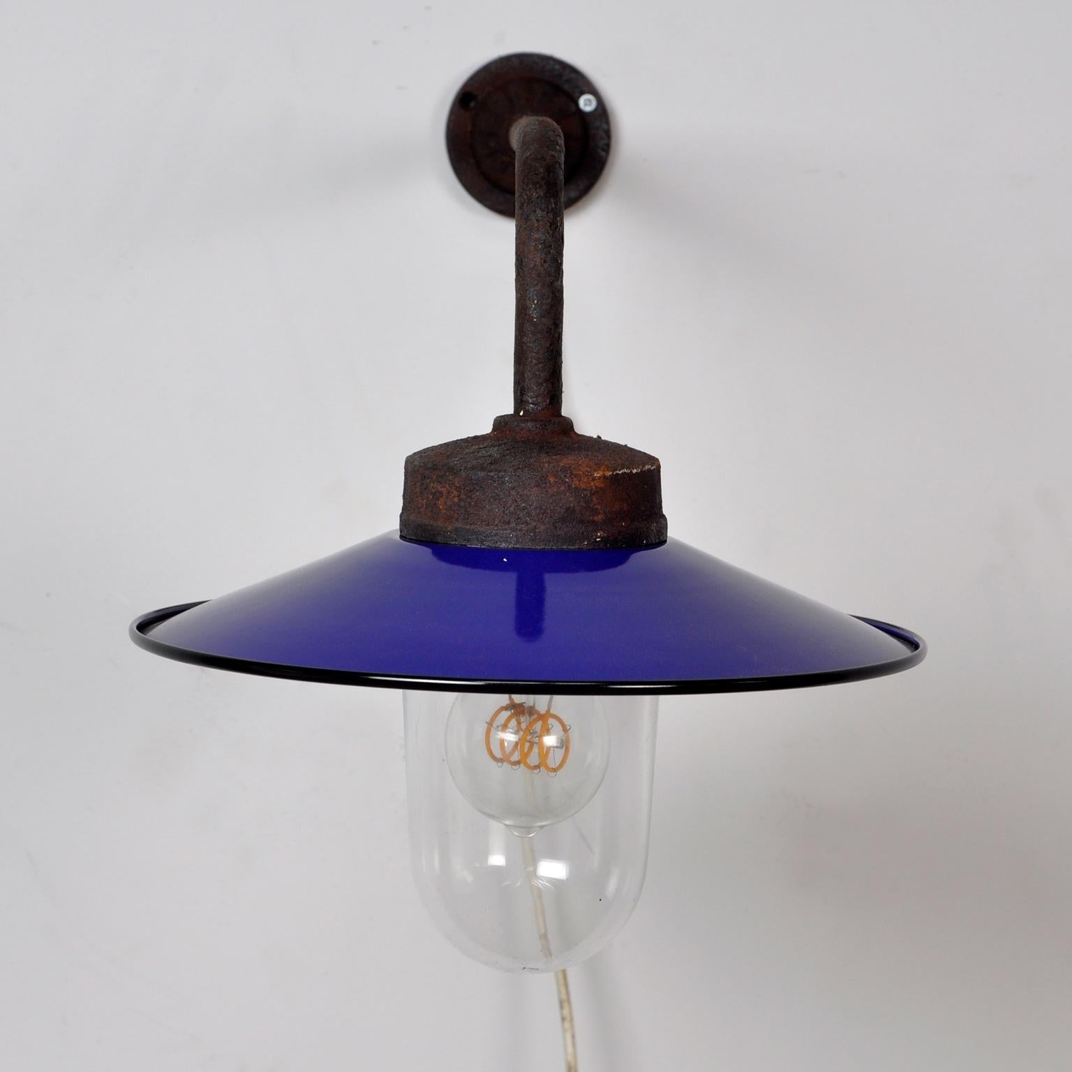 The lamp has a thick iron arm with cast iron beginning and end. The enamel blue shade is white at the inside for as much light as possible.
To be mounted on the wall.
