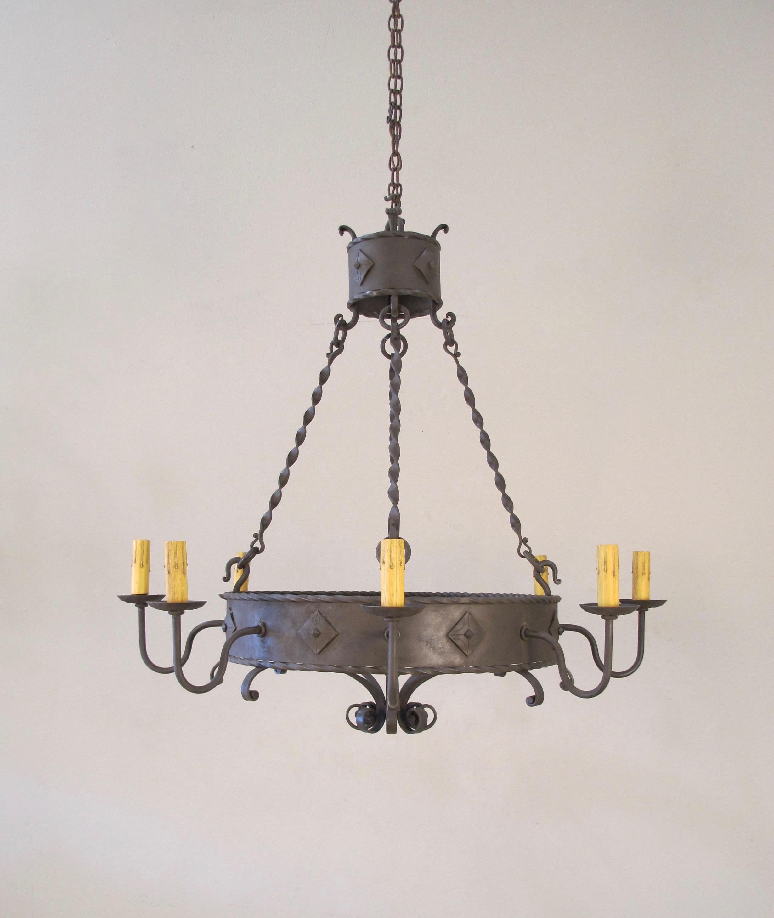 Our 8-light forged iron ring chandelier with Clavos and rope details. Made by chandelier. 8 medium base bulbs up to 60 watts/socket. UL approved, chain and canopy included.