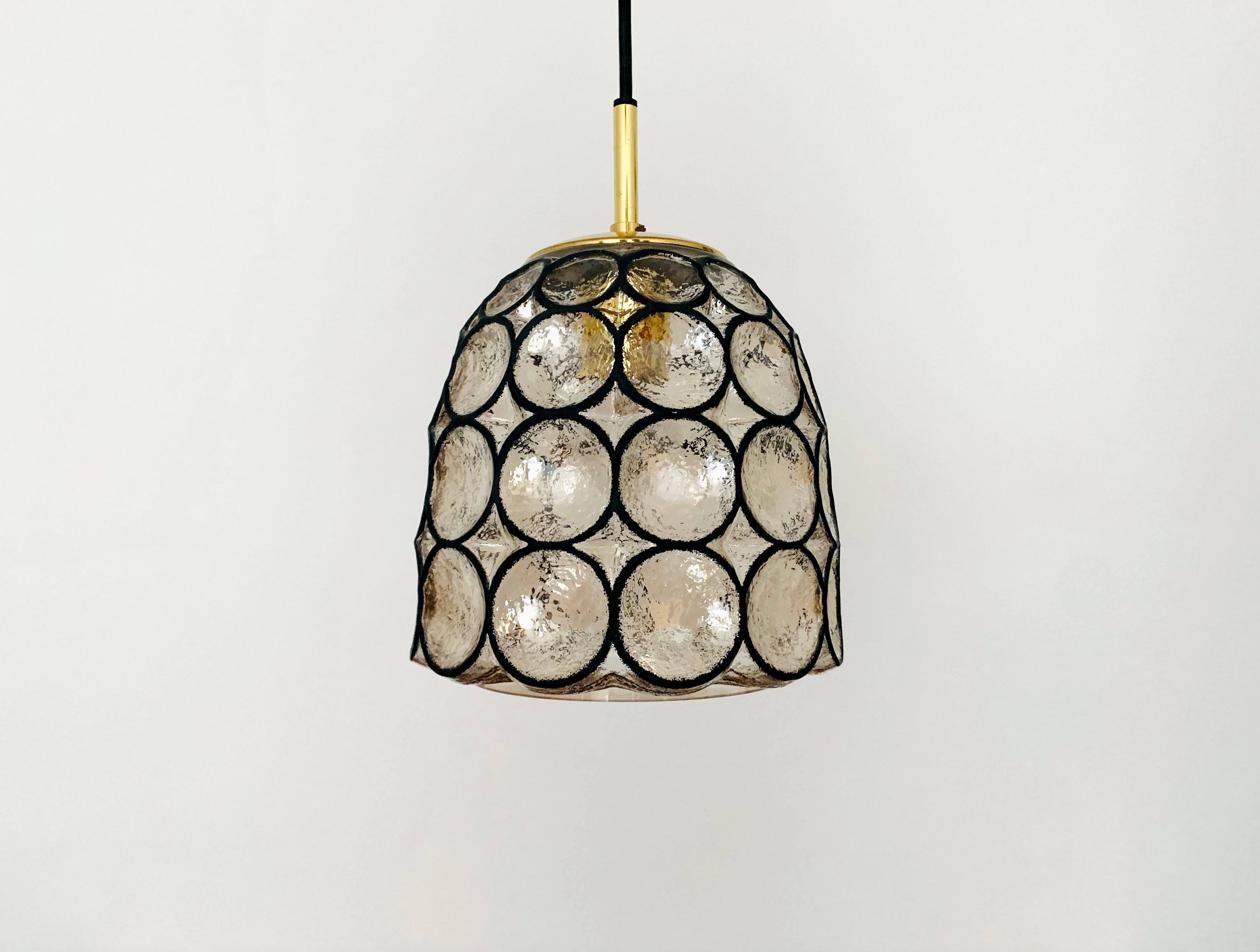 Very beautiful and rare pendant lamp from the 1960s.
The mouth-blown glass with the iron ring look is a real eye-catcher and impressively beautifully designed.
The lamp creates a great play of light in the room and enchants with its
