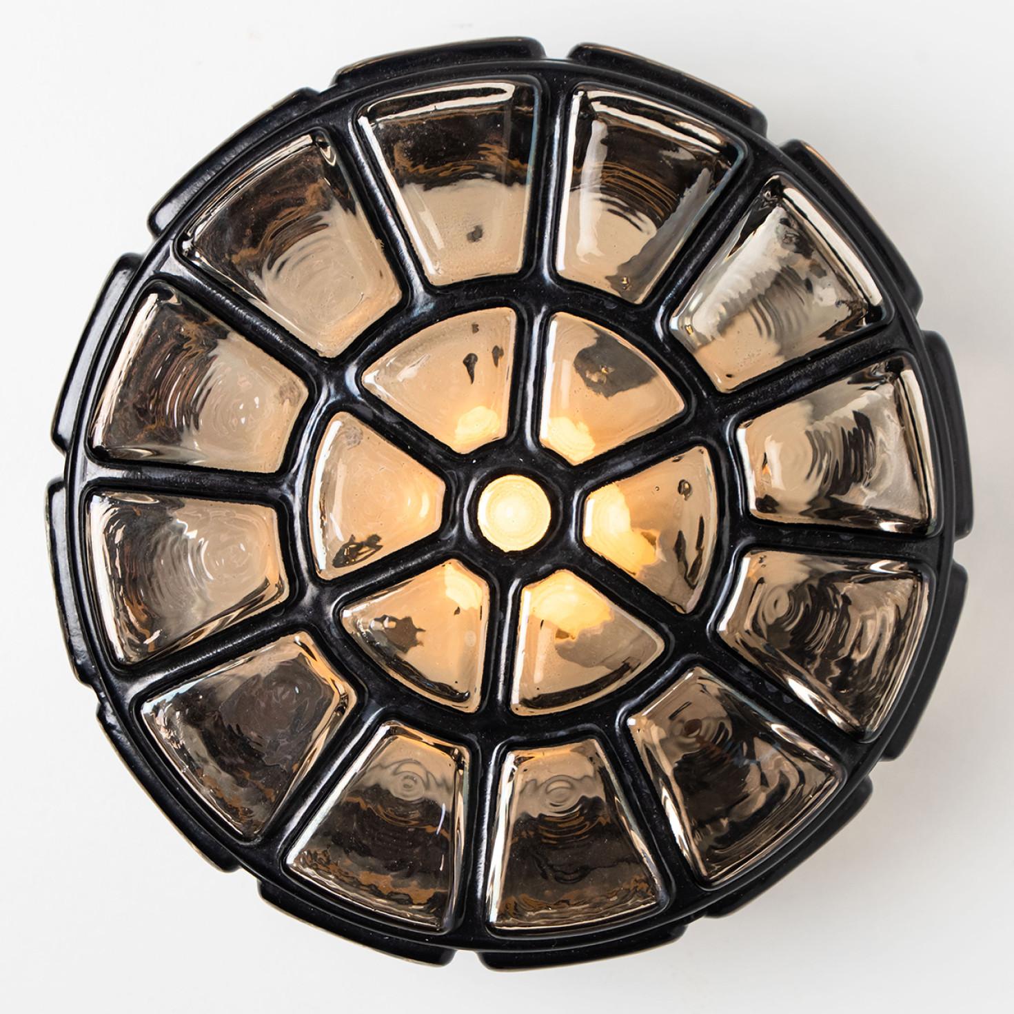 A wonderful round iron flush mount, circa 1970, made by Glashütte Limburg, Germany.
With hand blown smoked glass on brass base and a cage-like structure in iron. Illuminates beautifully.
Can either be mounted on the ceiling or on a wall.

Please