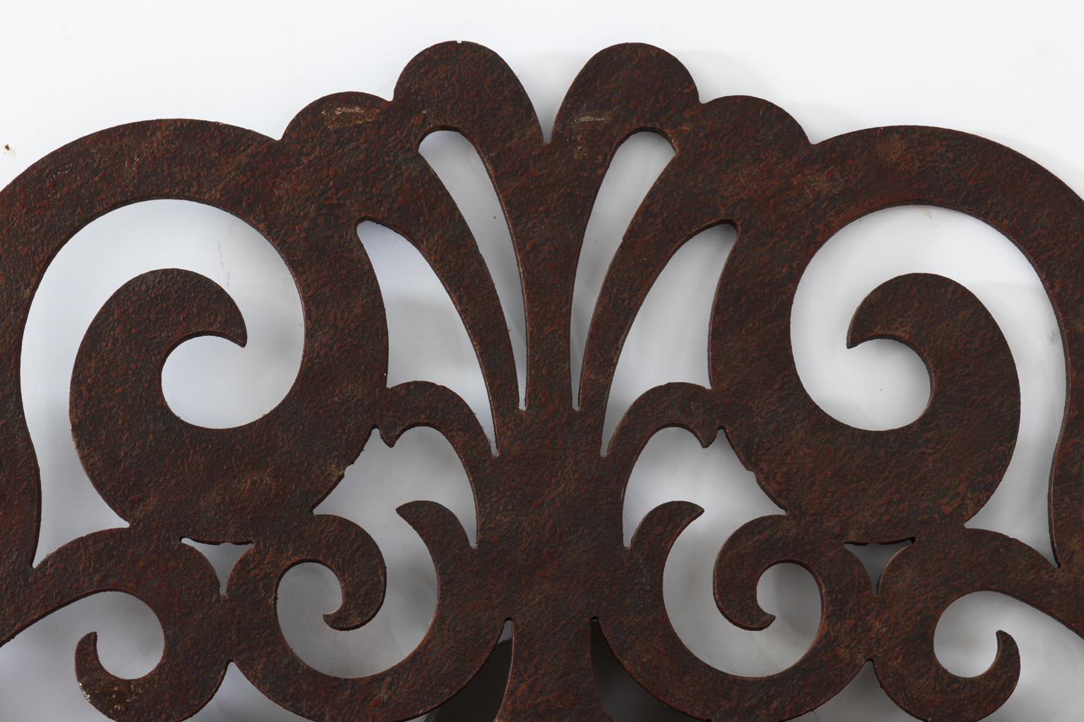 Continental style Iron mirror with scrolled crest that features a center palmette. The iron itself is in a distressed finish.