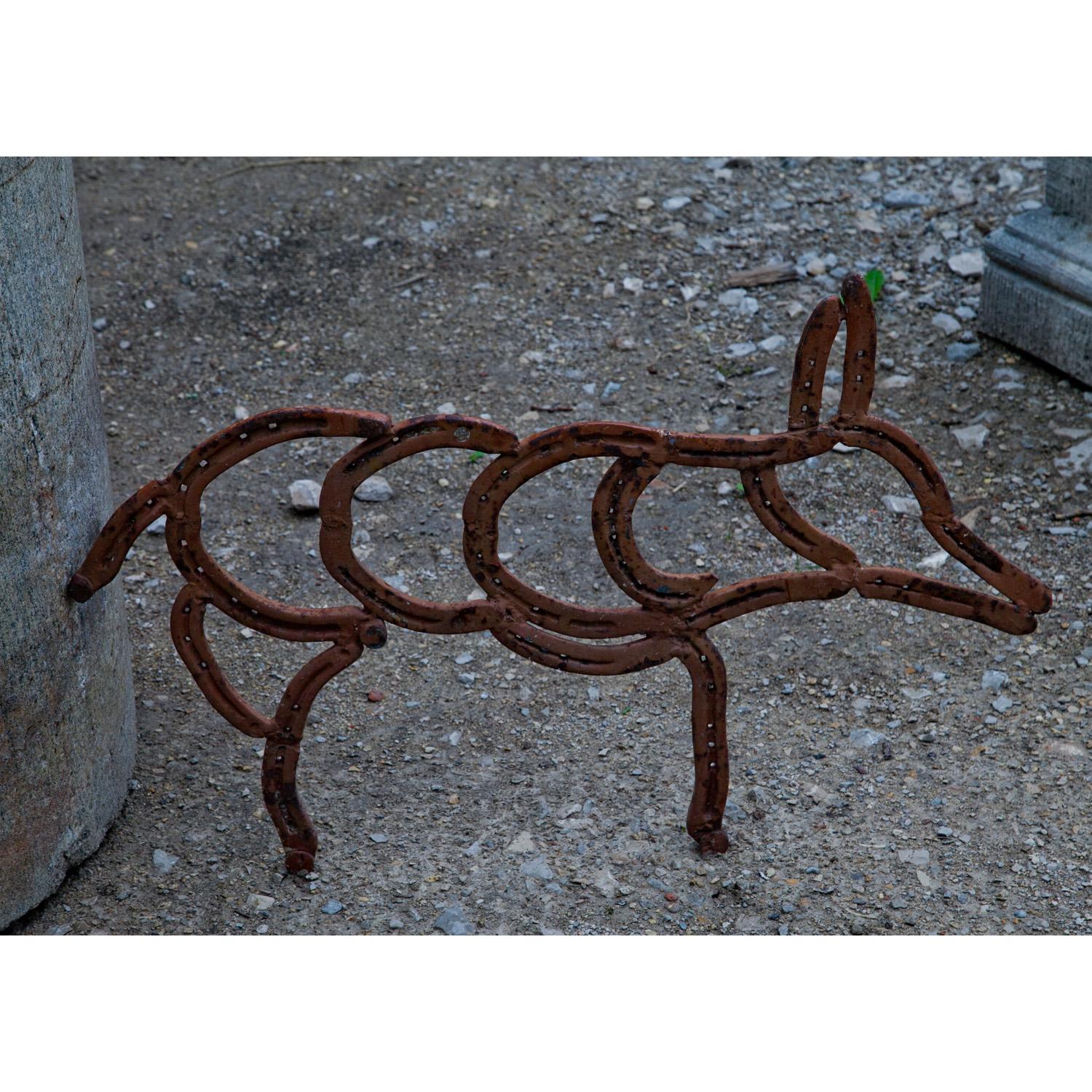 Sculpture of a little pig, made of single horseshoes, welded together.