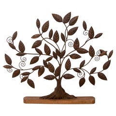Sculpture en fer d'un arbre avec des feuilles sur une base en bois couleur fer