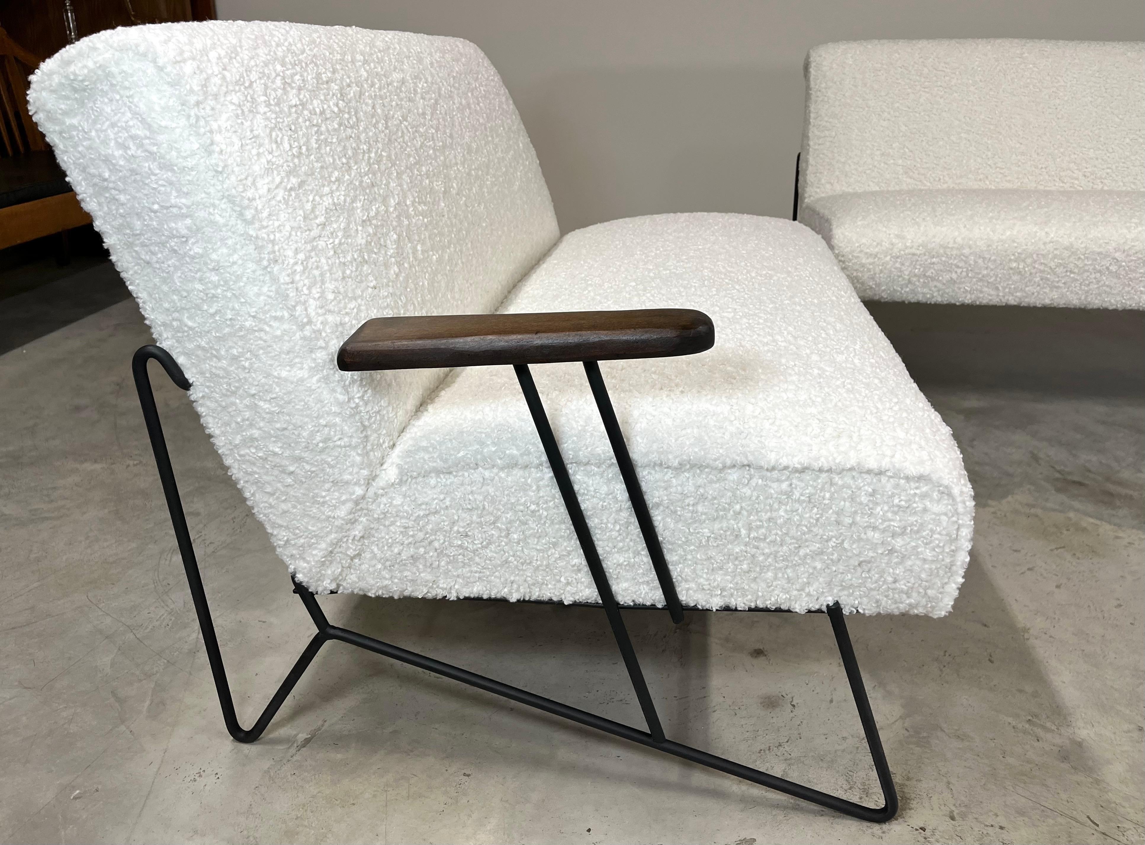 A beautiful mid-century 4-pc living room or sunroom suite having solid black iron frames with mahogany paddle arms newly upholstered in thick boucle’ fabric attributed to Dan Johnson. 
North America ca 1950. 
In excellent condition throughout. The