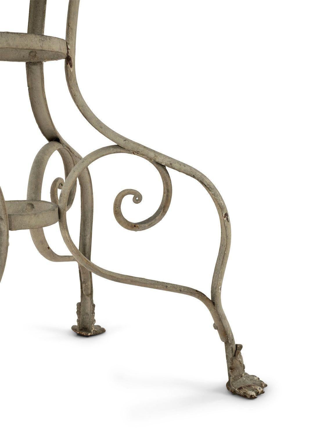 White-painted standing jardiniere in the style of Arras: painted wrought iron plant stand dating to late 19th century, France. Wire-work lattice jardiniere raised upon scrolled wrought iron base and cast lion's paw shaped feet. Currently contains