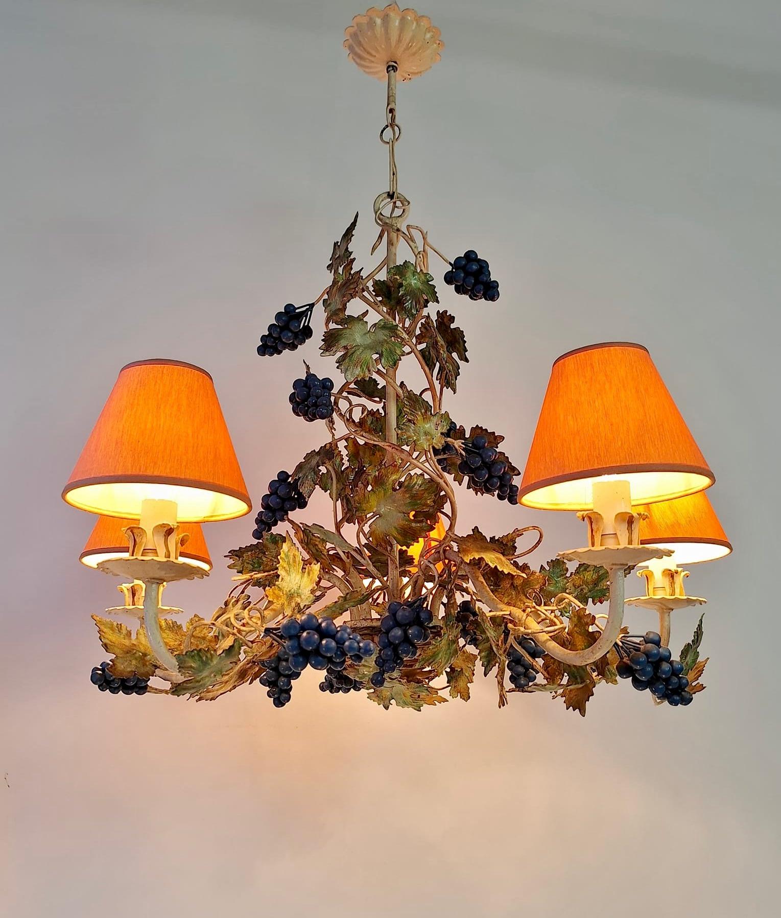 A wonderful Italian 1950's white iron 5 candelabra light chandelier. This beautiful chandelier consists of a gracefully scrolled iron frame with an assortment of colored leaves and grape clusters. 

