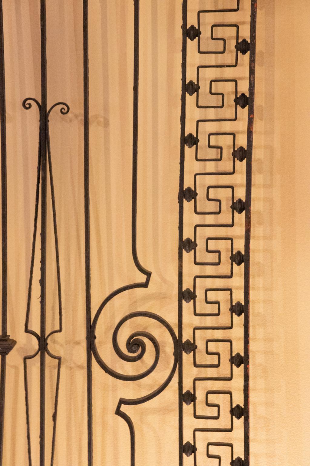 Iron window guard with Greek Key border and scrolled design, circa 19th century. Please note of wear consistent with age including paint loss.