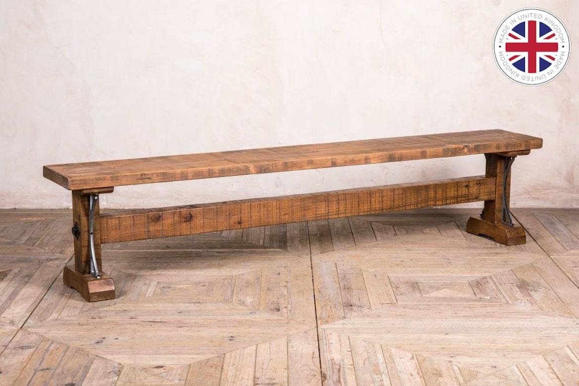 A fine Ironbridge Bespoke pine bench, 20th century. 

The Ironbridge Bespoke pine bench is a beautifully made bench made from extra thick reclaimed pine, but the standout feature is the stunning iron decoration at the base of the bench, giving it