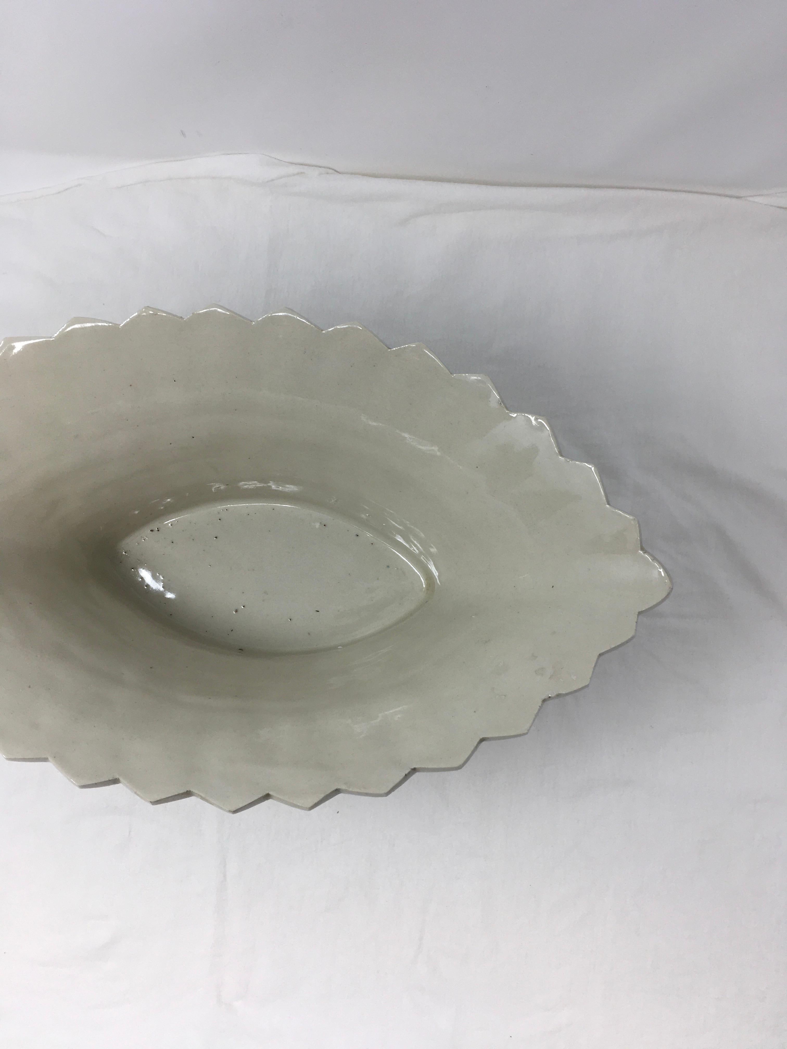 This beautiful ironstone basket bowl has a zig zag accent on the top rim. It also features a floral detail.