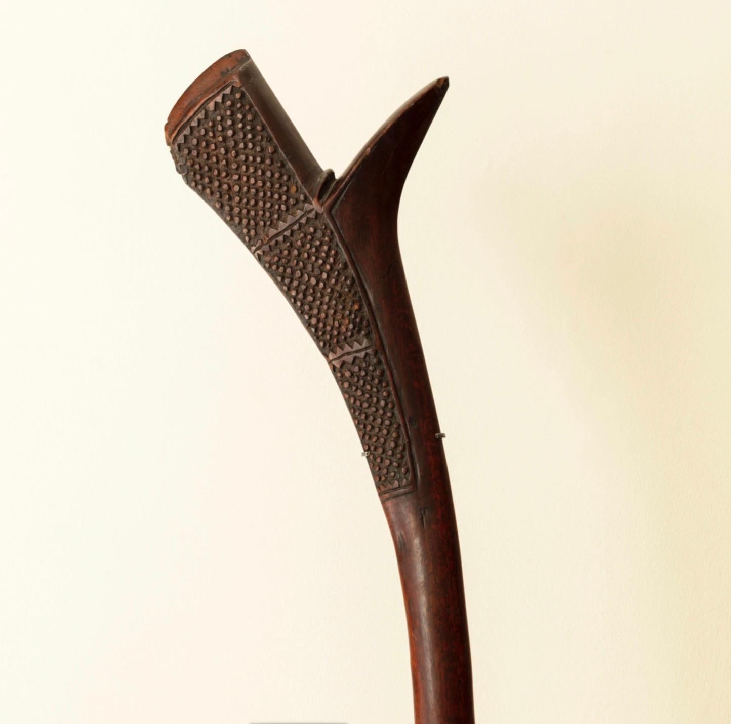 Kriegskeule 'Sali' in Form eines Pistolenstocks. Wurzel aus Eisenholz, geschnitzt mit traditionellen Motiven. Ein ausgezeichnetes Exemplar, montiert auf einem Sonderständer aus patinierter Bronze.

Maße: Höhe 44 cm auf Ständer.

Fidschi, Ende