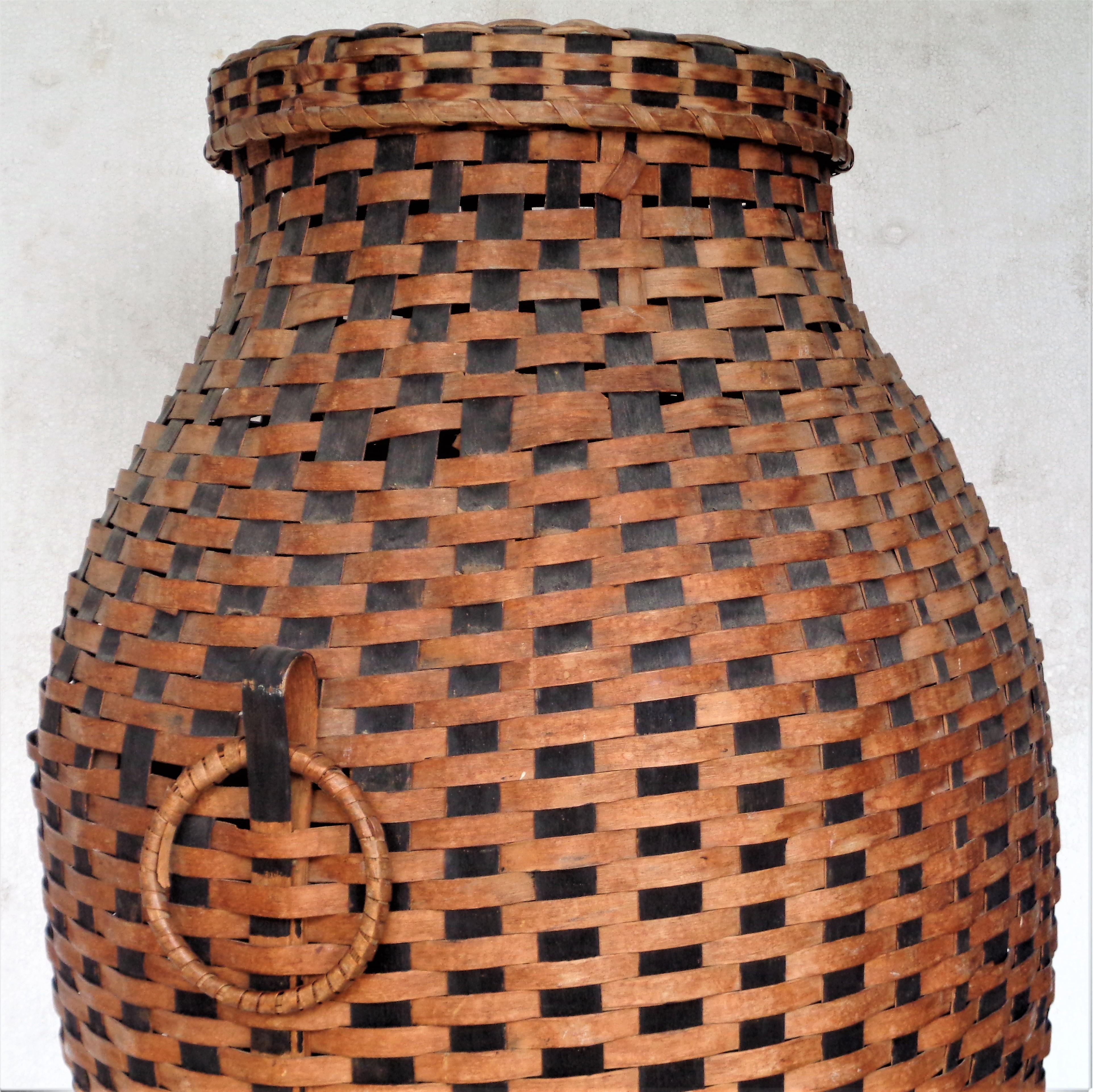 Panier de rangement antique à couvercle en éclisse, tissé à la main, avec de grandes poignées en anneau des deux côtés et un motif contrasté de taches naturelles et noires. Circa 1890 - 1910. Regardez toutes les photos et lisez le rapport de