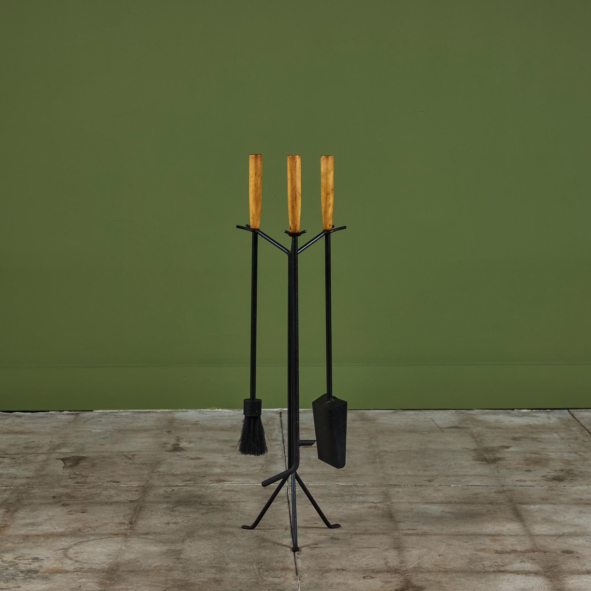 Conçu par Irving Harper sous la direction de George Nelson Associates pour Howard Miller c.1950s, USA. Cet ensemble d'outils de cheminée comprend trois outils en fer forgé sur un support en fer forgé à trois pieds. L'ensemble comprend un balai, un