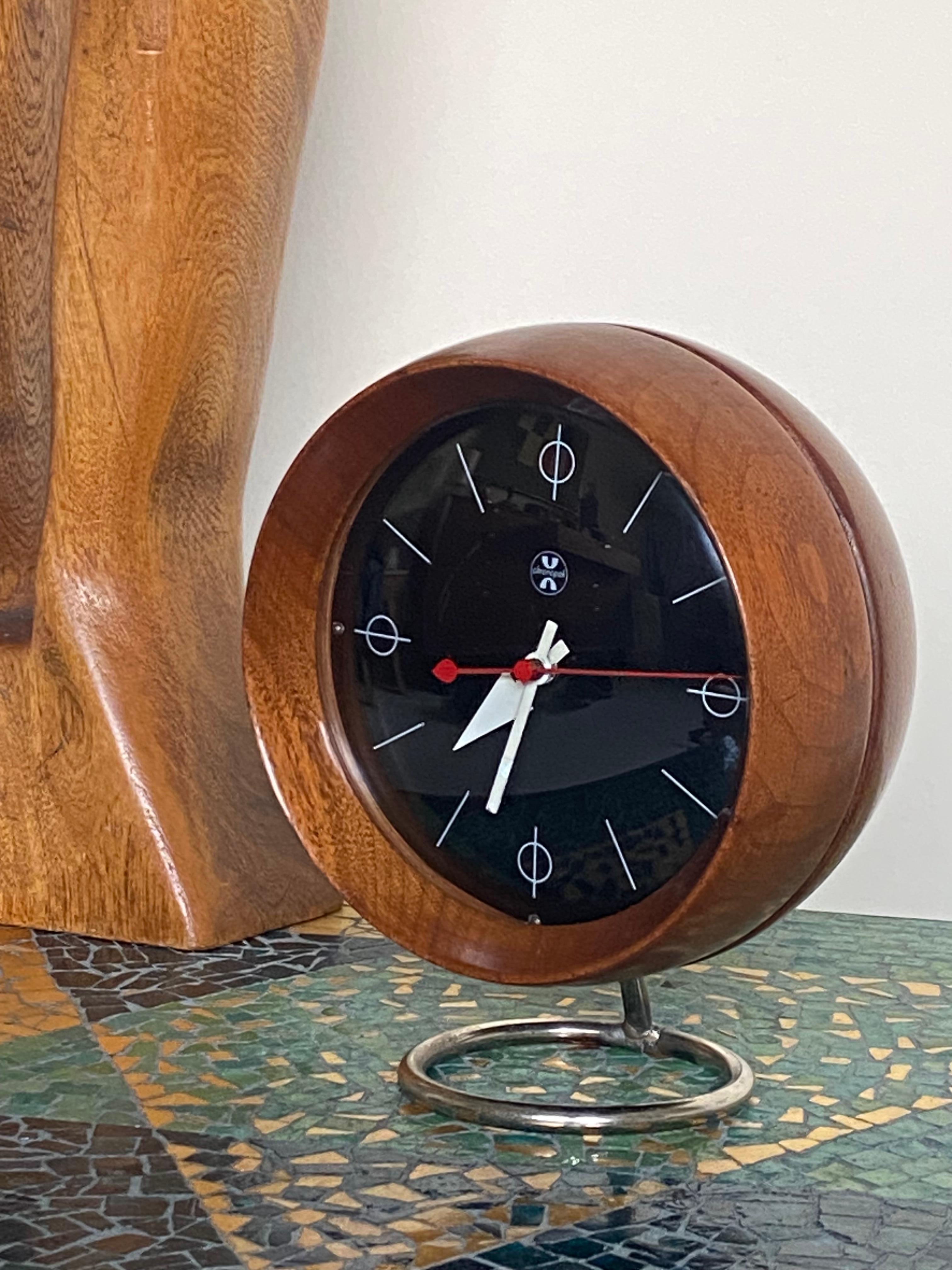One of the earlier designs for the Howard Miller clock company is this walnut table clock model 4765 circa 1949 designed by Irving Harper for George Nelson & Associates and the Howard Miller Company. Globe shaped body in walnut with a glass front