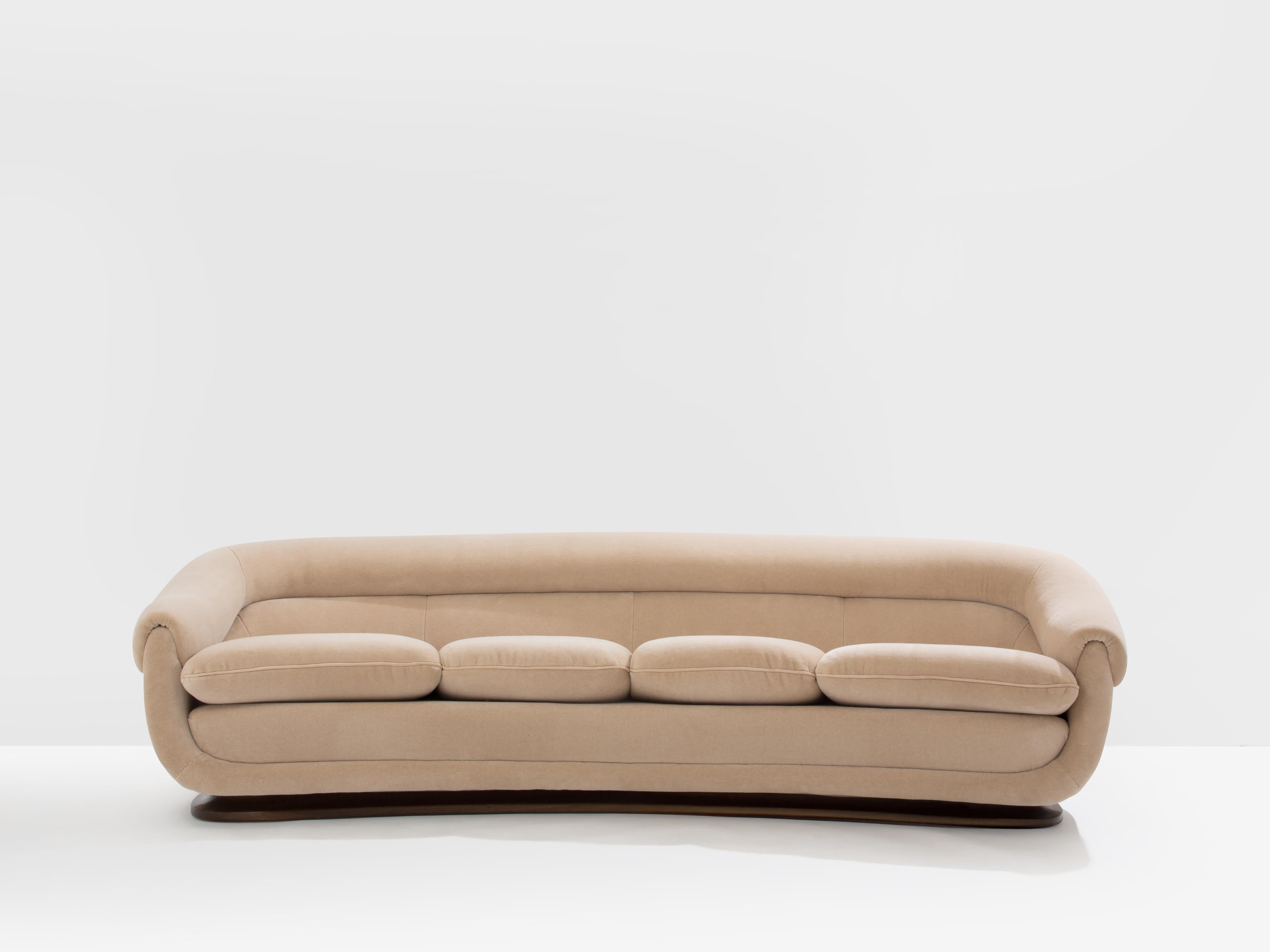 This exceptional sofa, attributed to Isa Bergamo, and dating from the 1940s, is an outstanding example of post-war Art Deco Italian design. Its crescent-shaped seat rests on a low wooden walnut base, while its rounded, substantial arms and