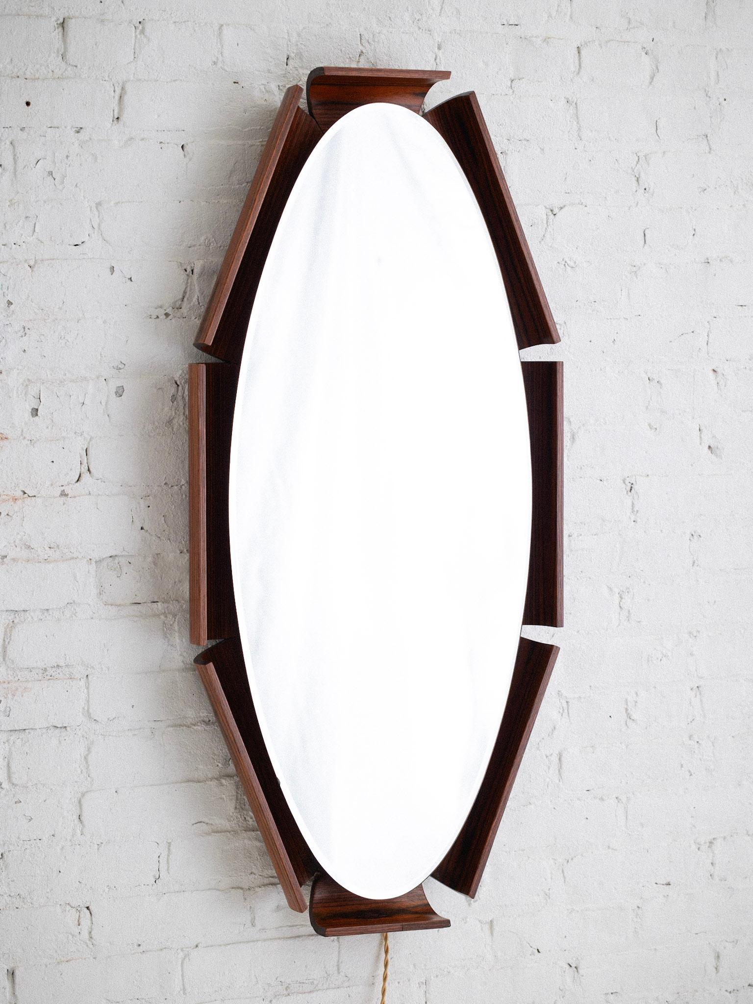 A mid century Italian light up oval wall mirror by ISA Bergamo. Rosewood 