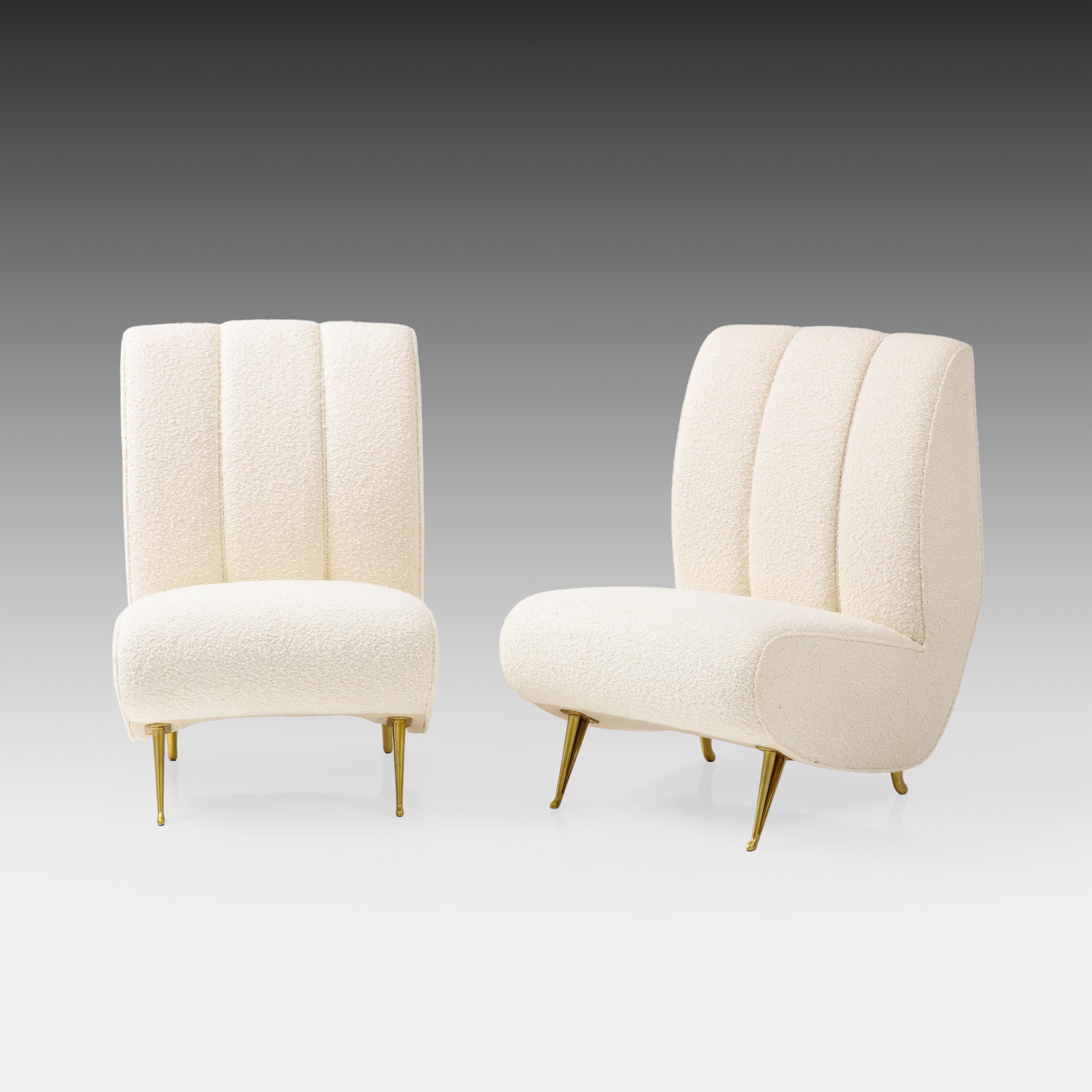 ISA Bergamo rare exquisite pair of channel back lounge or slipper chairs with gilt metal legs in ivory bouclé, Italy, 1950s.  These elegant chairs have gentle curves throughout including its channel back, seat, and signature cutout gilt metal front