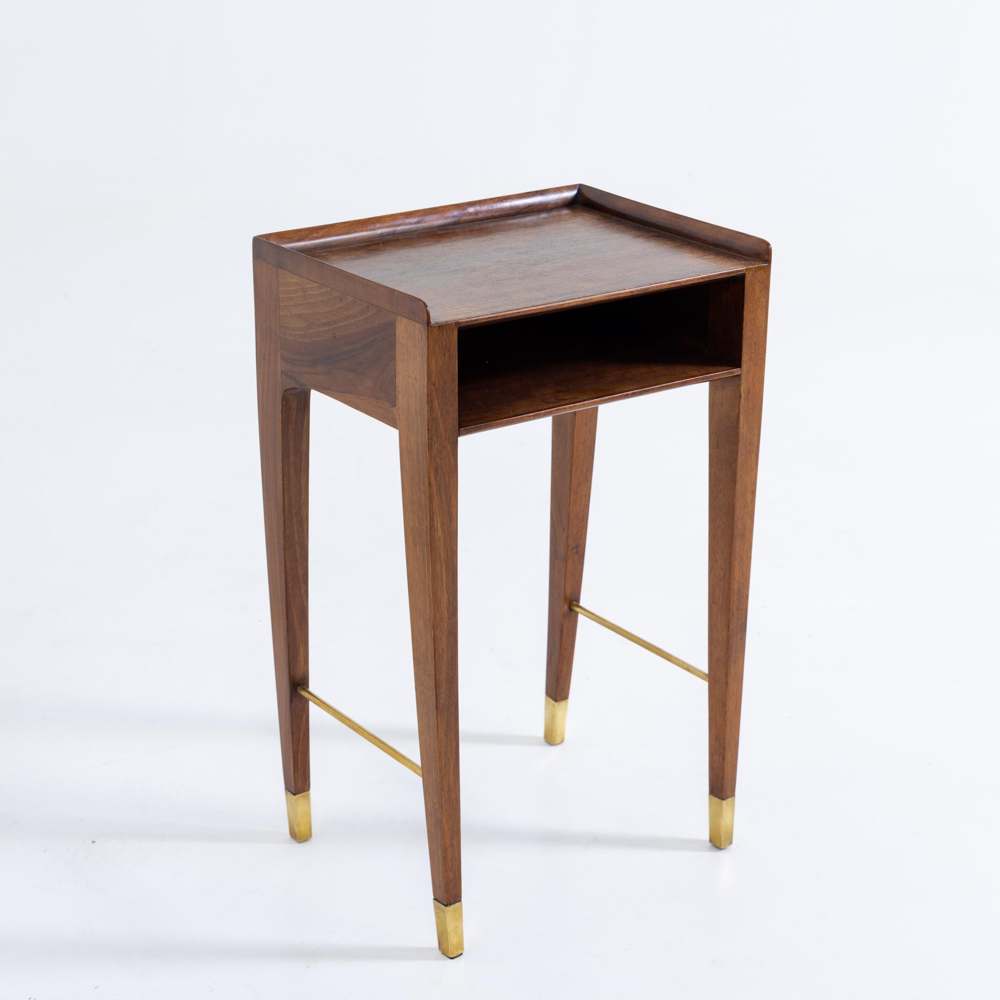 Sidetable with brass braces and feet, one compartment and a low ledge on three sides of the top.