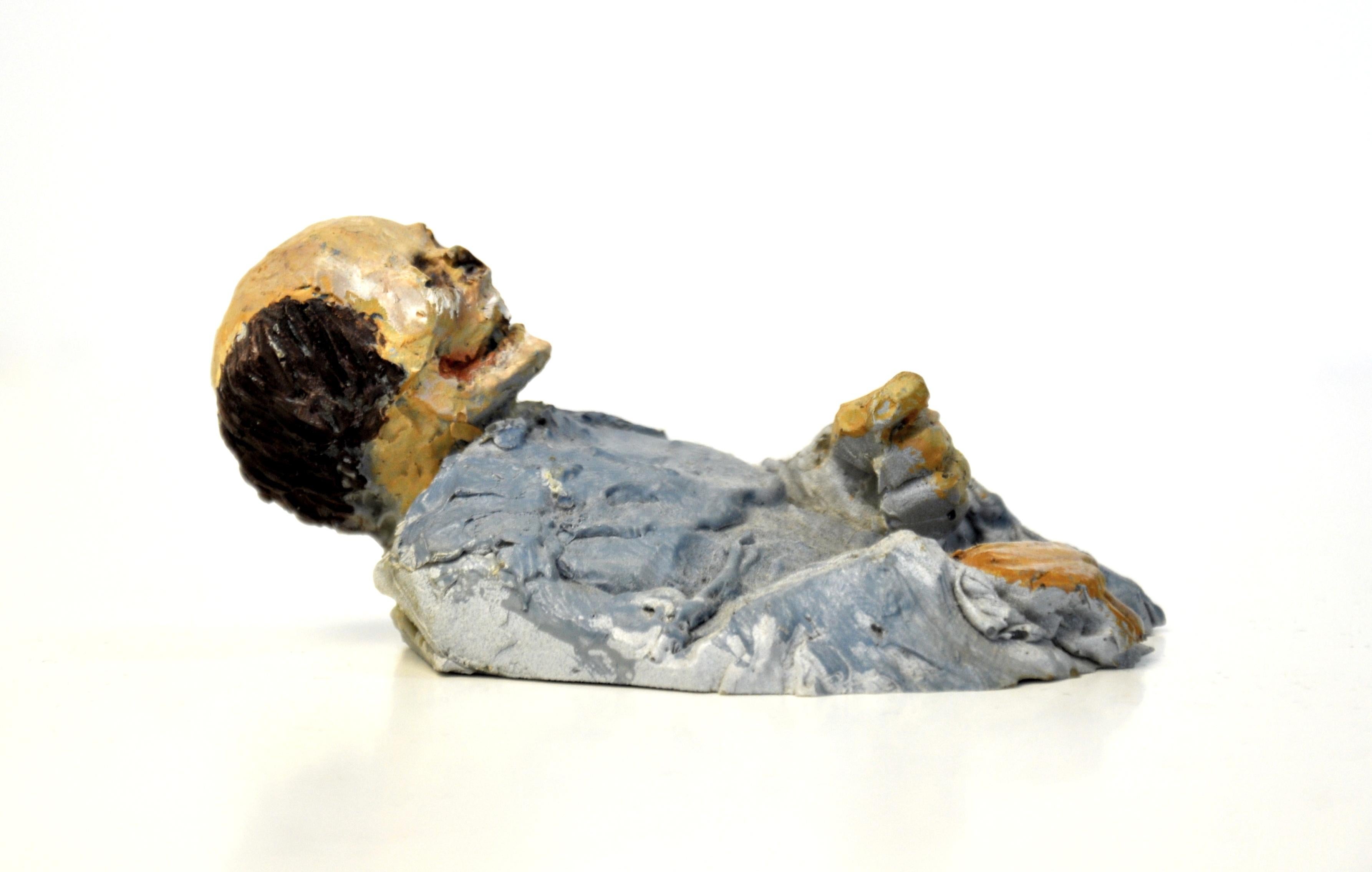 A resin zombie skeleton figure sculpture by Isaac Cordal, a contemporary Brussels-based Spanish sculptor, from the Urban Inertia exhibition, titled Viva la Muerte. The bust appears to protrude from whatever surface it is placed on, much like a